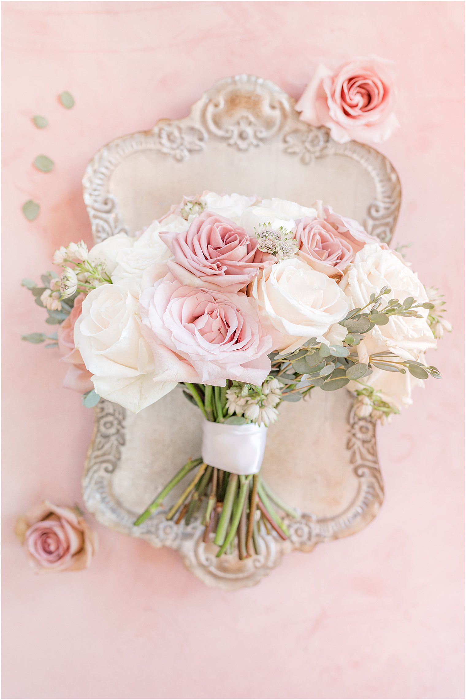 pink and white rose bouquet rests on silver tray 