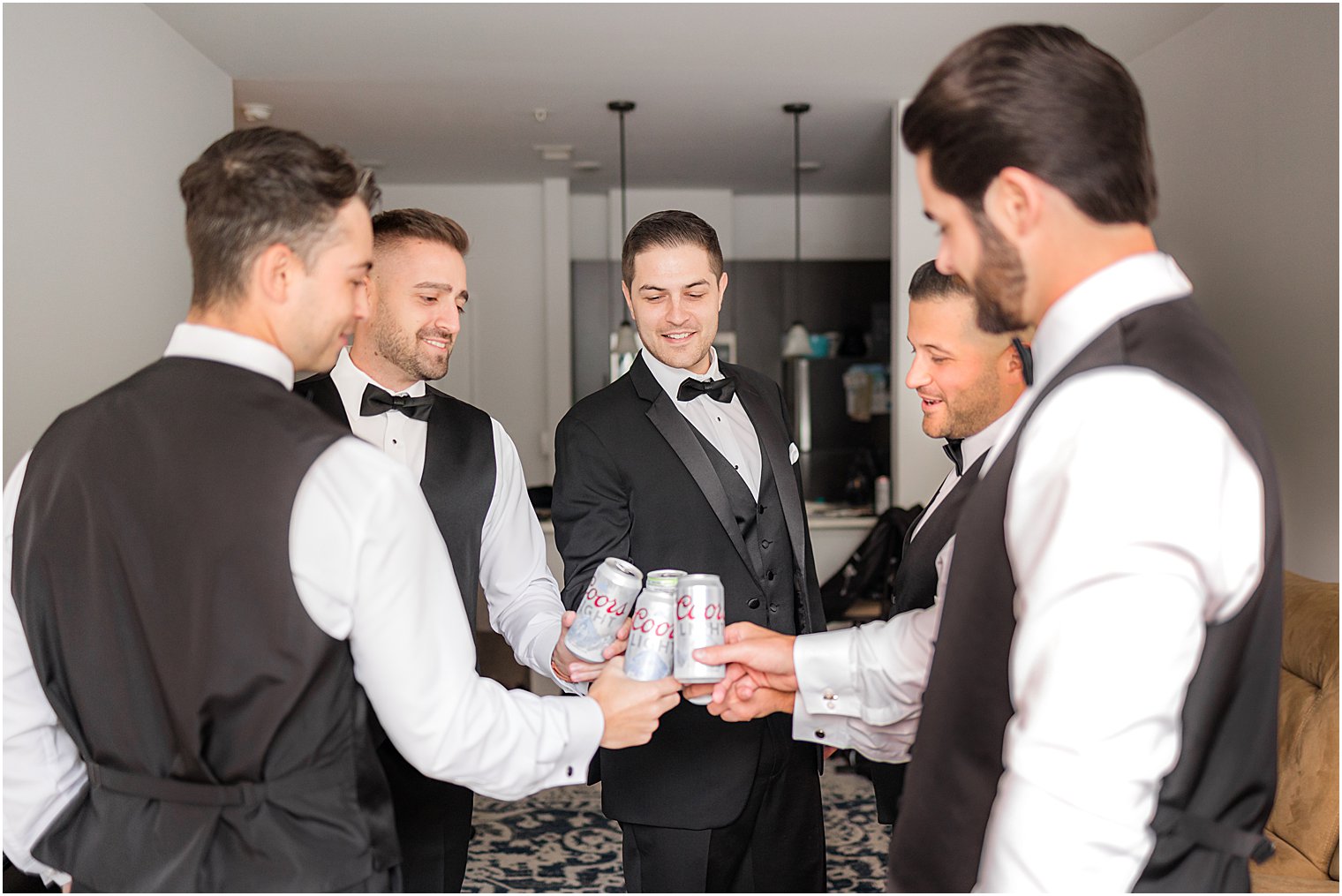 groom and groomsmen toast beers during prep for New Jersey wedding 
