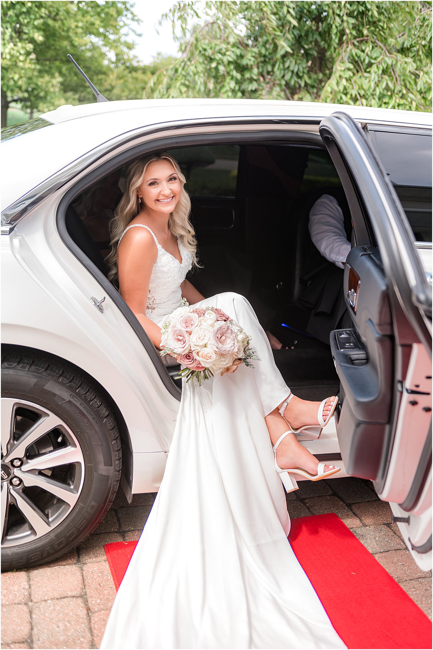bride steps out of classic white car at church 