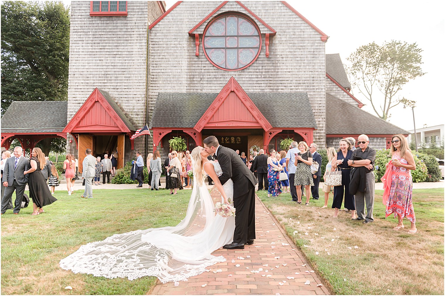 bride and groom kiss outside wooden church in New Jersey