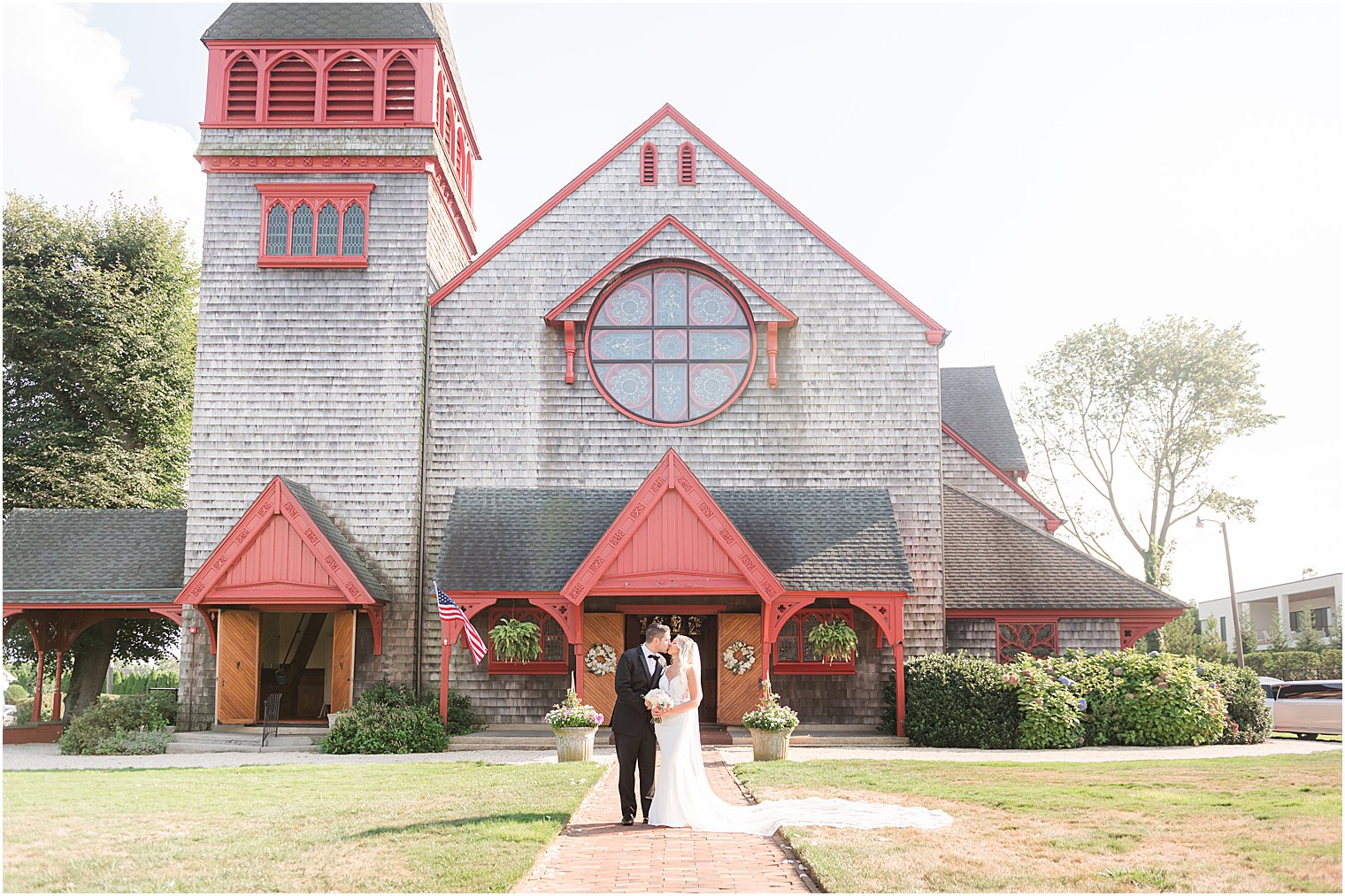 newlyweds kiss by small wooden church in New Jersey