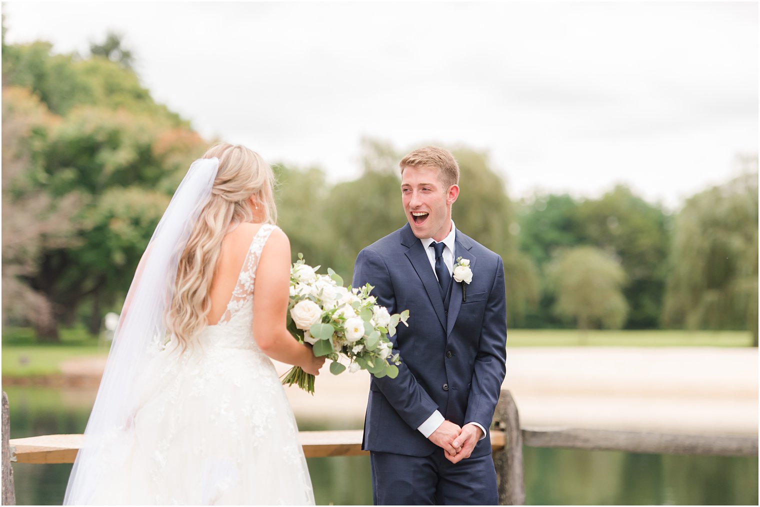 groom turns to see bride shocked during first look at Windows on the Water at Frogbridge