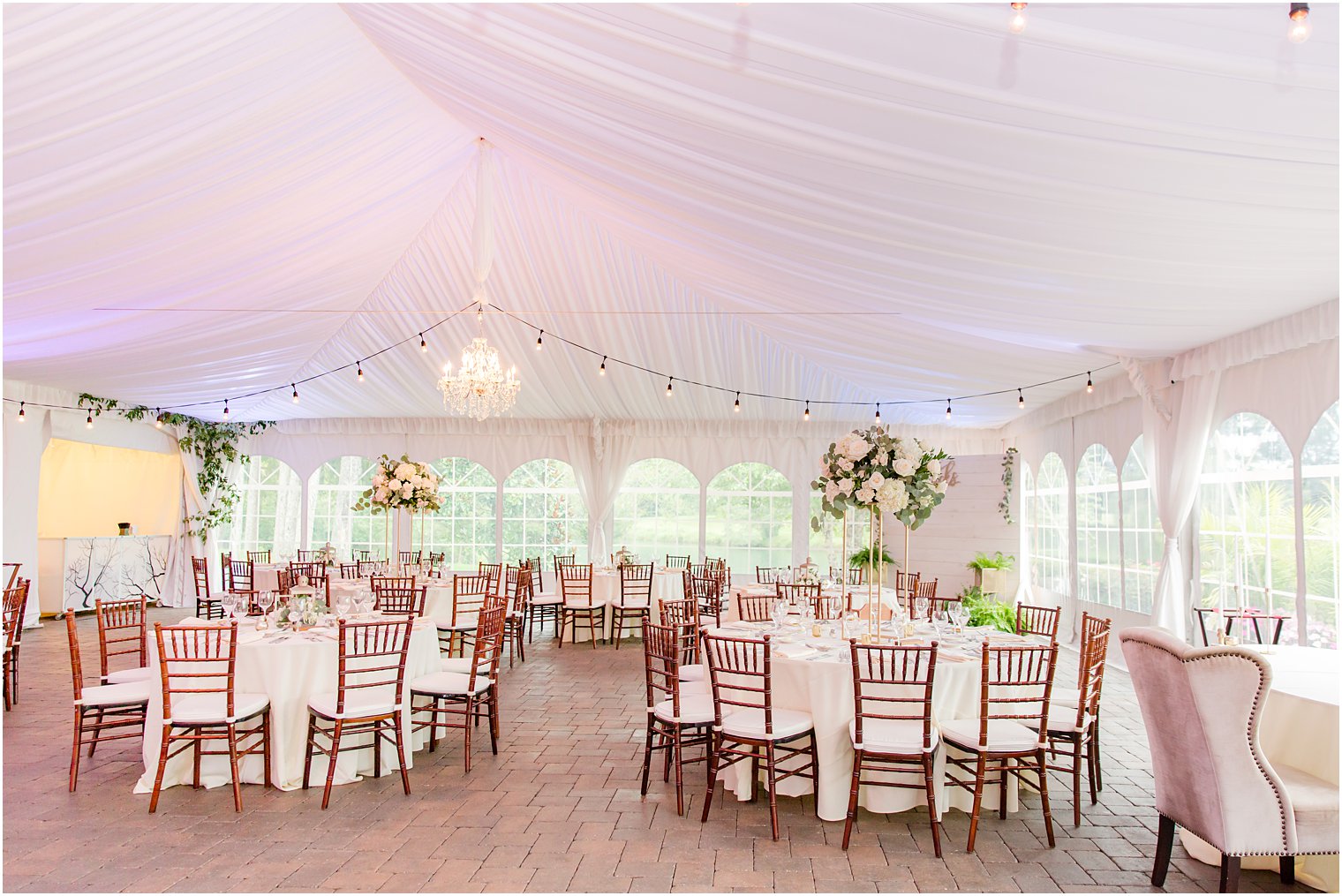 tented wedding reception with white floral centerpieces at Windows on the Water at Frogbridge