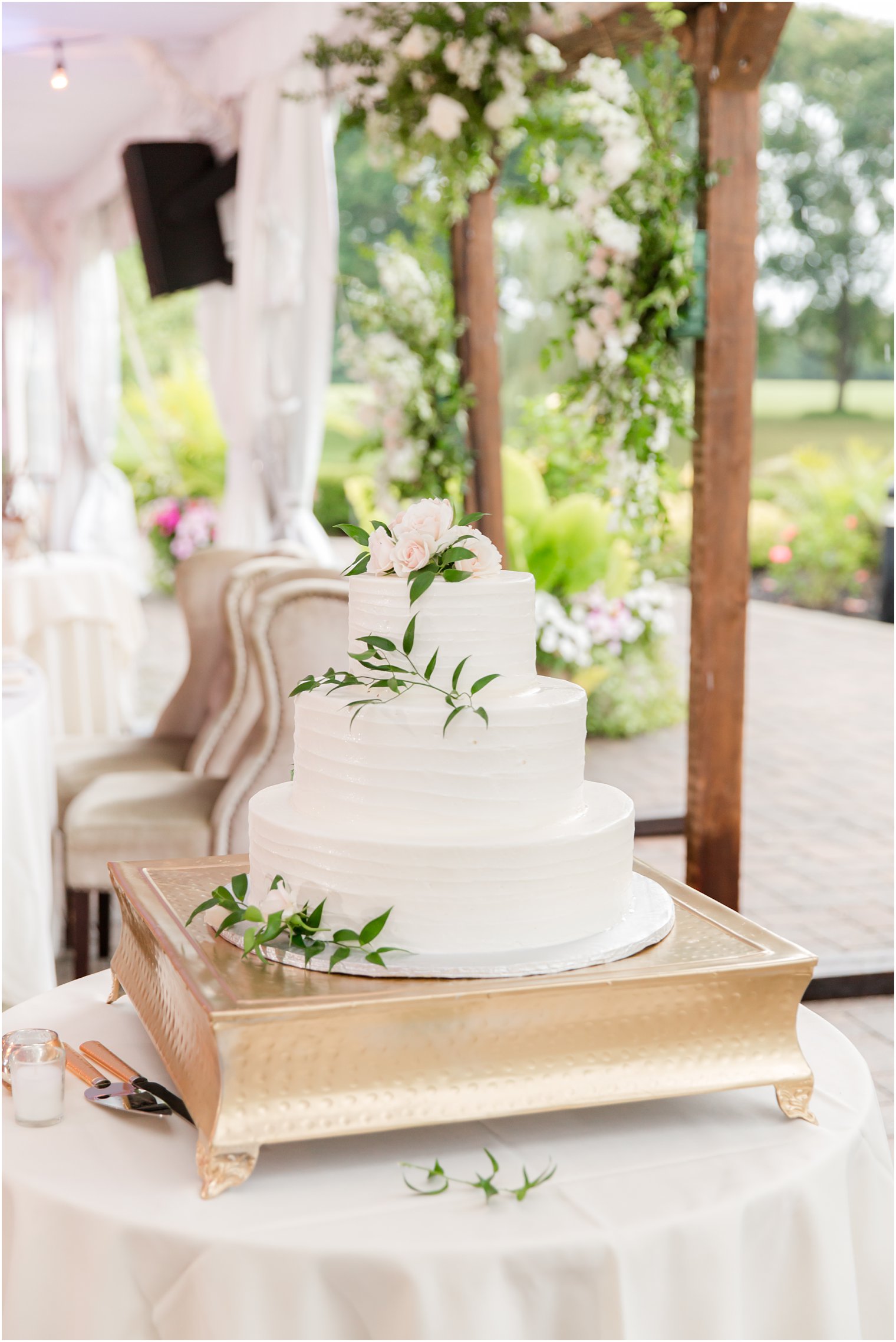 tiered wedding cake sitting on gold tray 