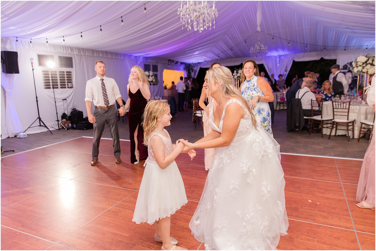 bride dances with flower girl during reception 
