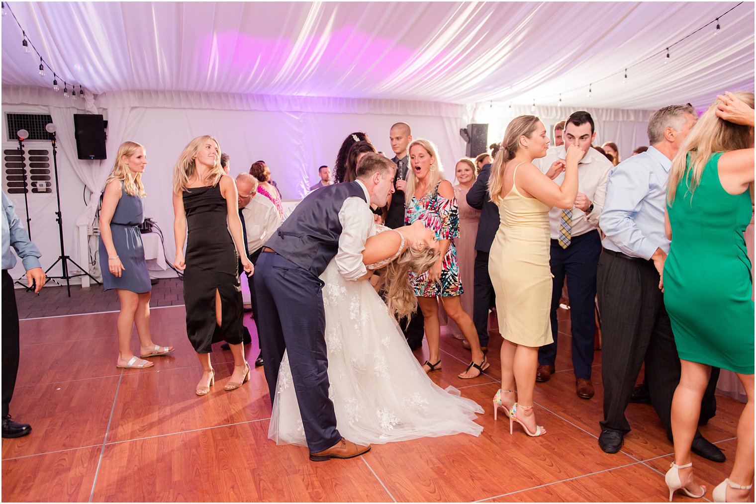 groom dips bride during reception at Windows on the Water at Frogbridge