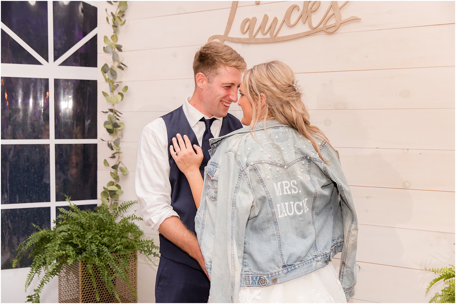 bride and groom hug with bride in custom jean jacket 