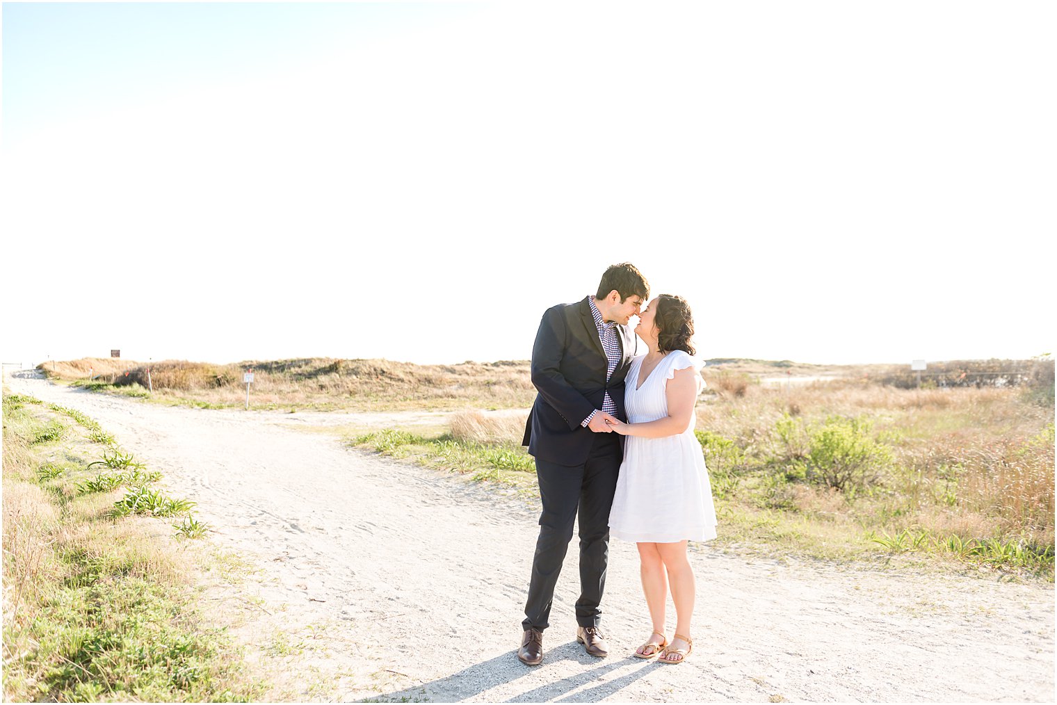 engaged couple kiss on path near Avalon NJ beach