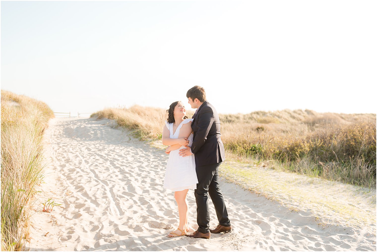 groom twirls bride into him on sandy path in Avalon NJ