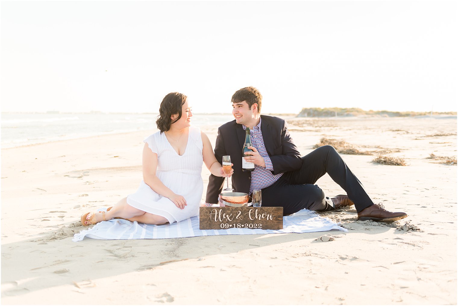 engaged couple has picnic on beach during beach engagement session in Avalon NJ