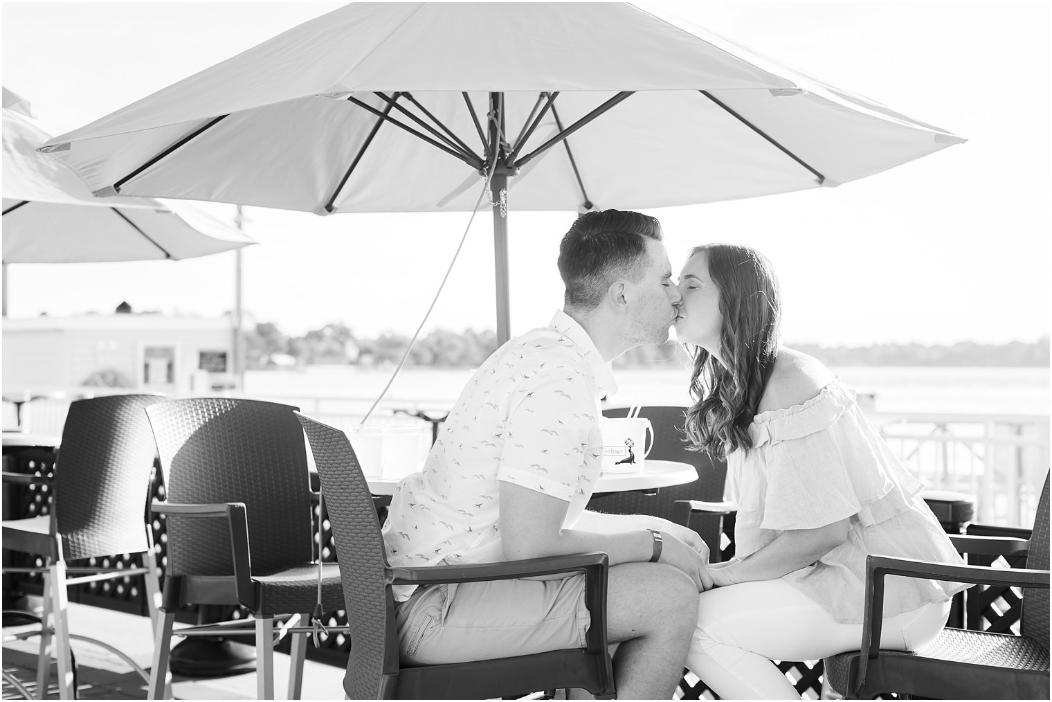 engaged couple kisses near table at 9th Avenue Pier