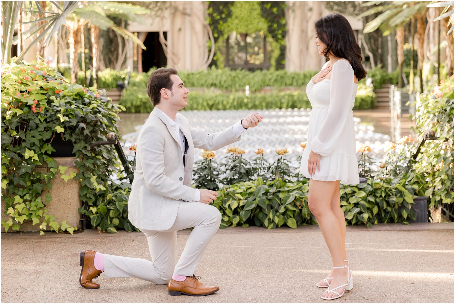 man in grey suit holds out ring during Longwood Gardens proposal
