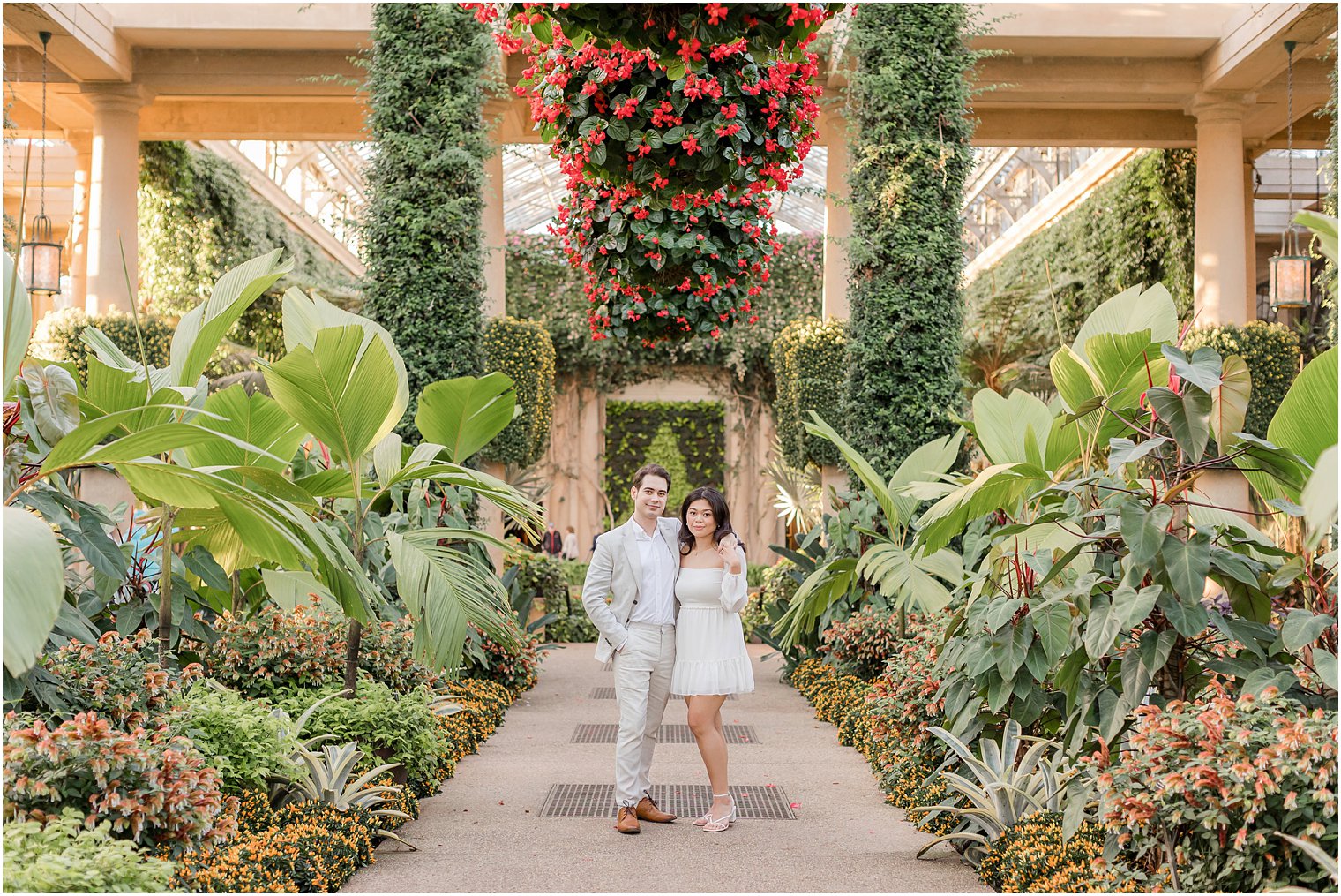engaged couple walks through conservatory of plants at Longwood Gardens
