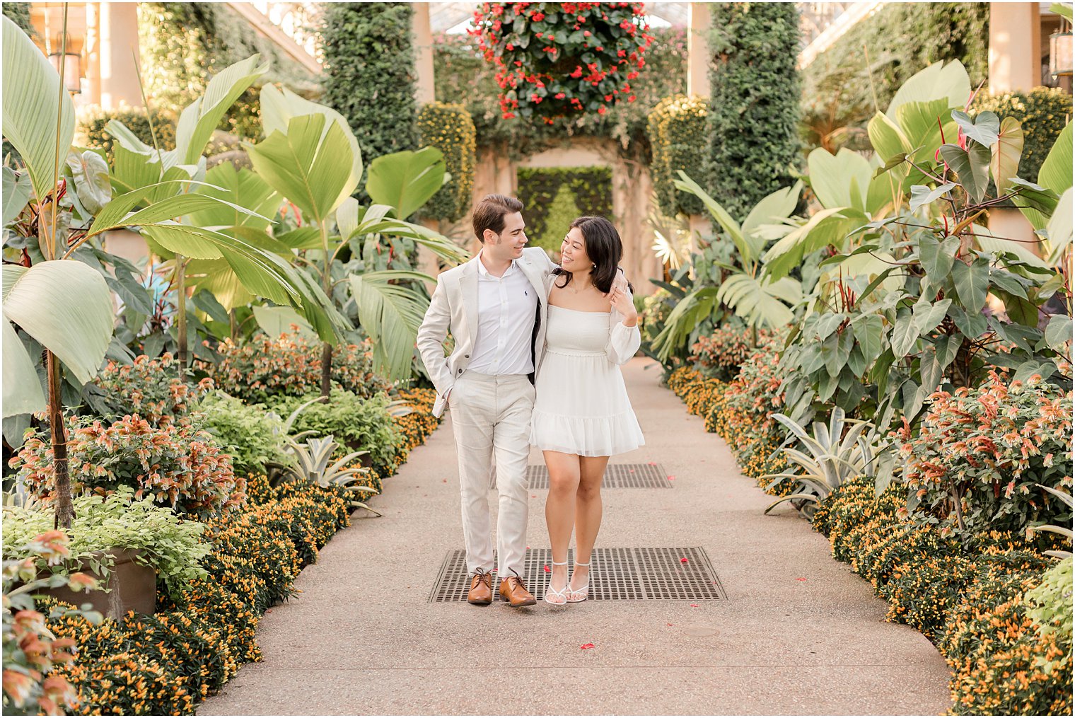 woman and man hold hands walking between rows of plants