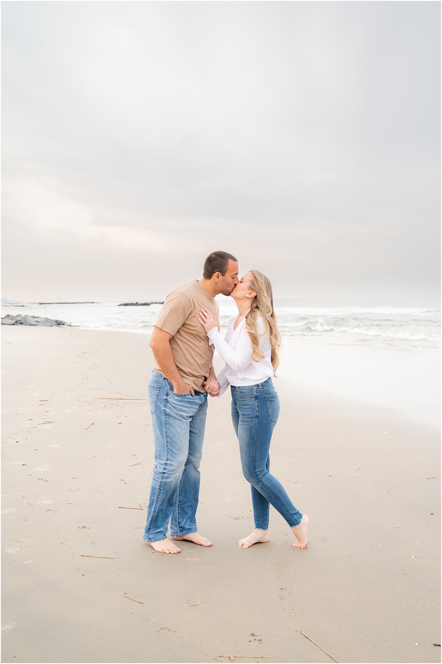 bride and groom kiss during portraits on beach during Spring Lake engagement session