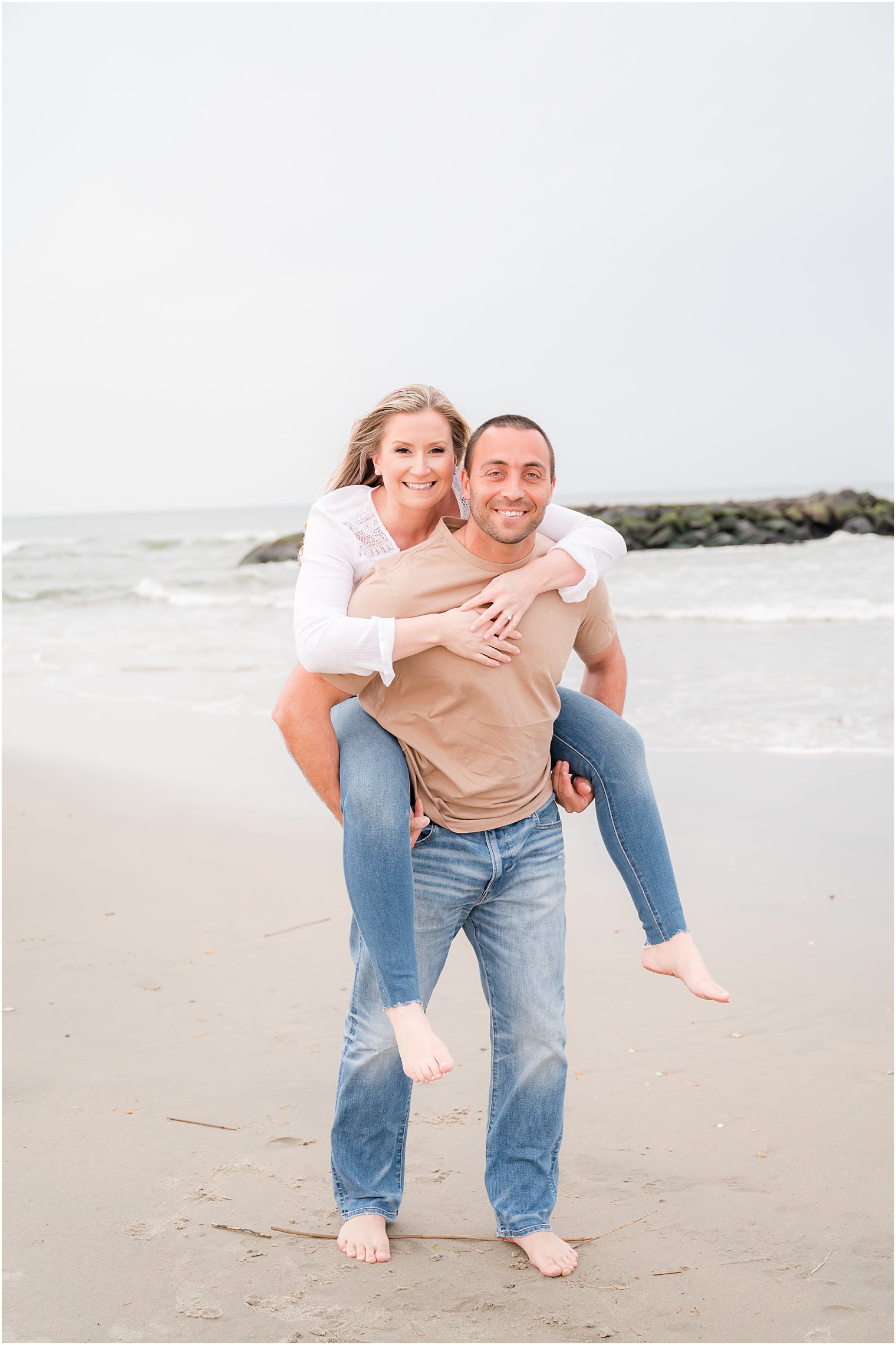 man gives fiancee piggy back ride on Spring Lake Beach