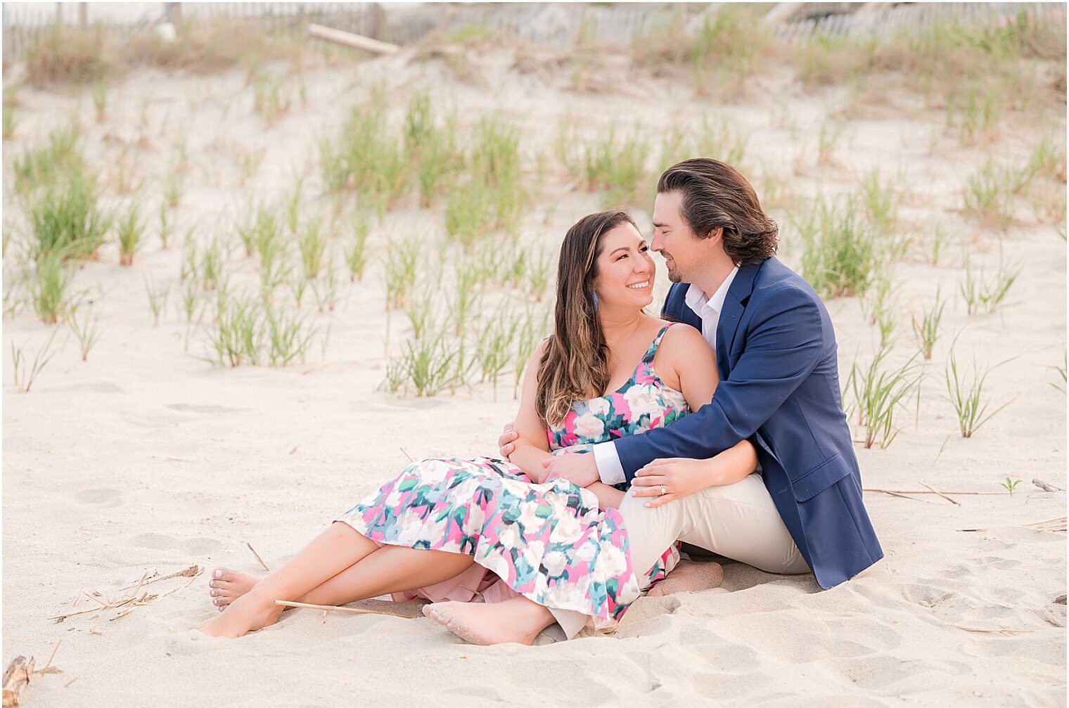 future husband and wife sitting in the sand enjoying their Beach Engagement Session at Sea Bright NJ
