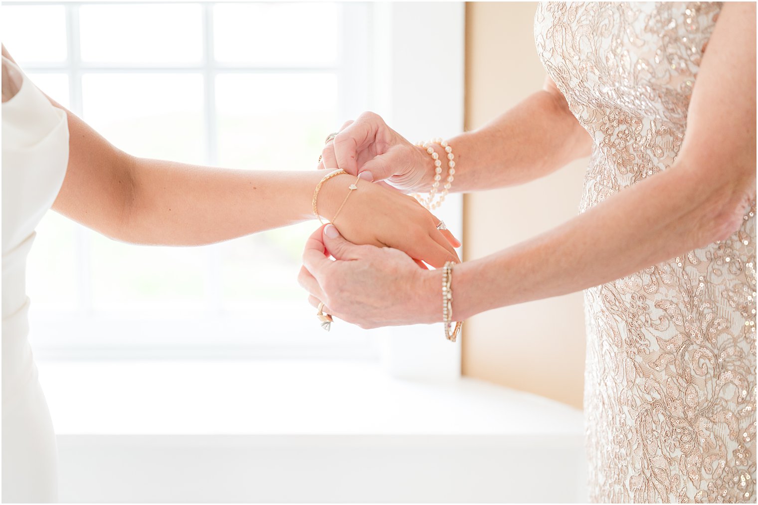 woman puts bracelet on bride's arm inside Ryland Inn suite 