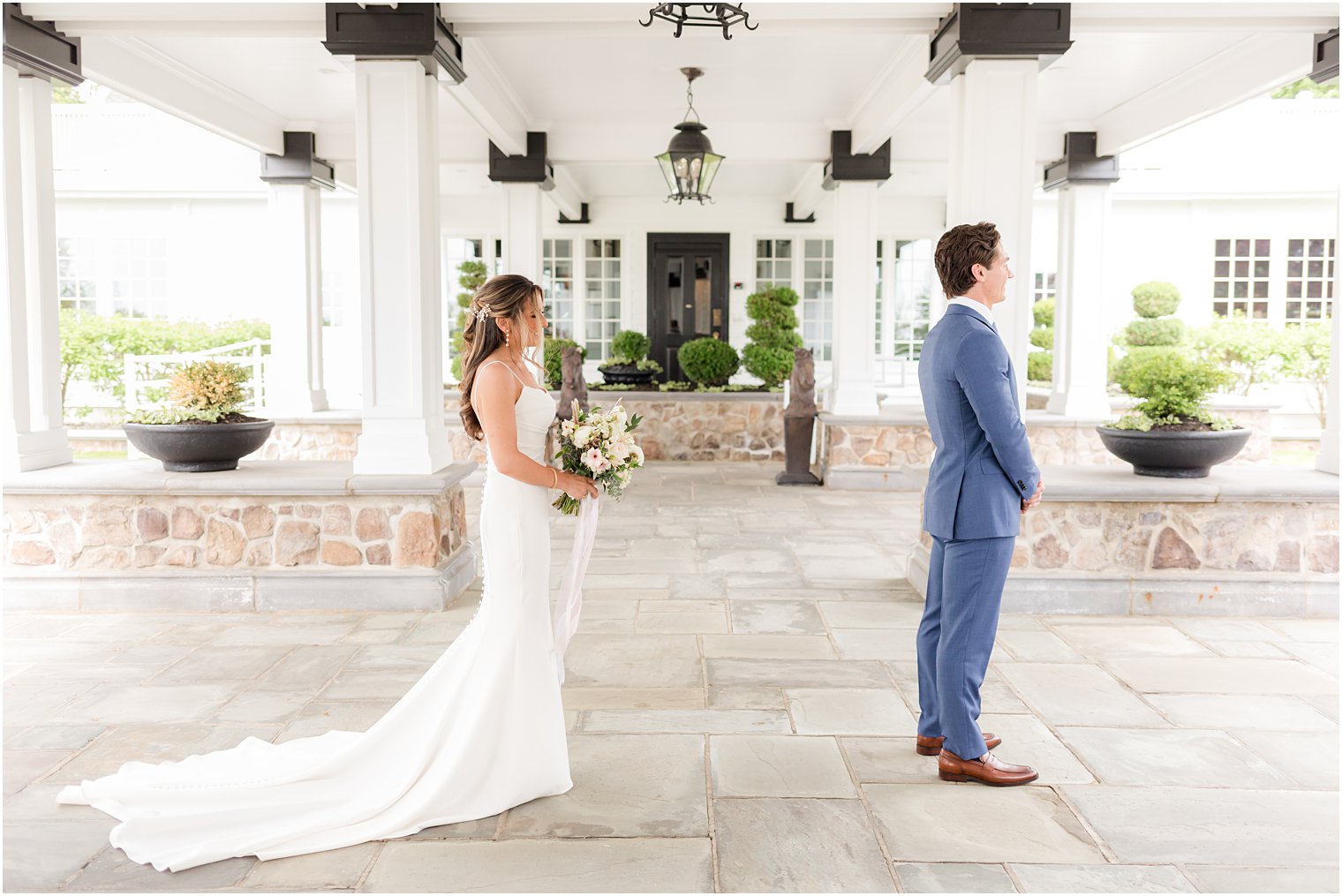 bride walks to meet groom for first look under awning at Ryland Inn