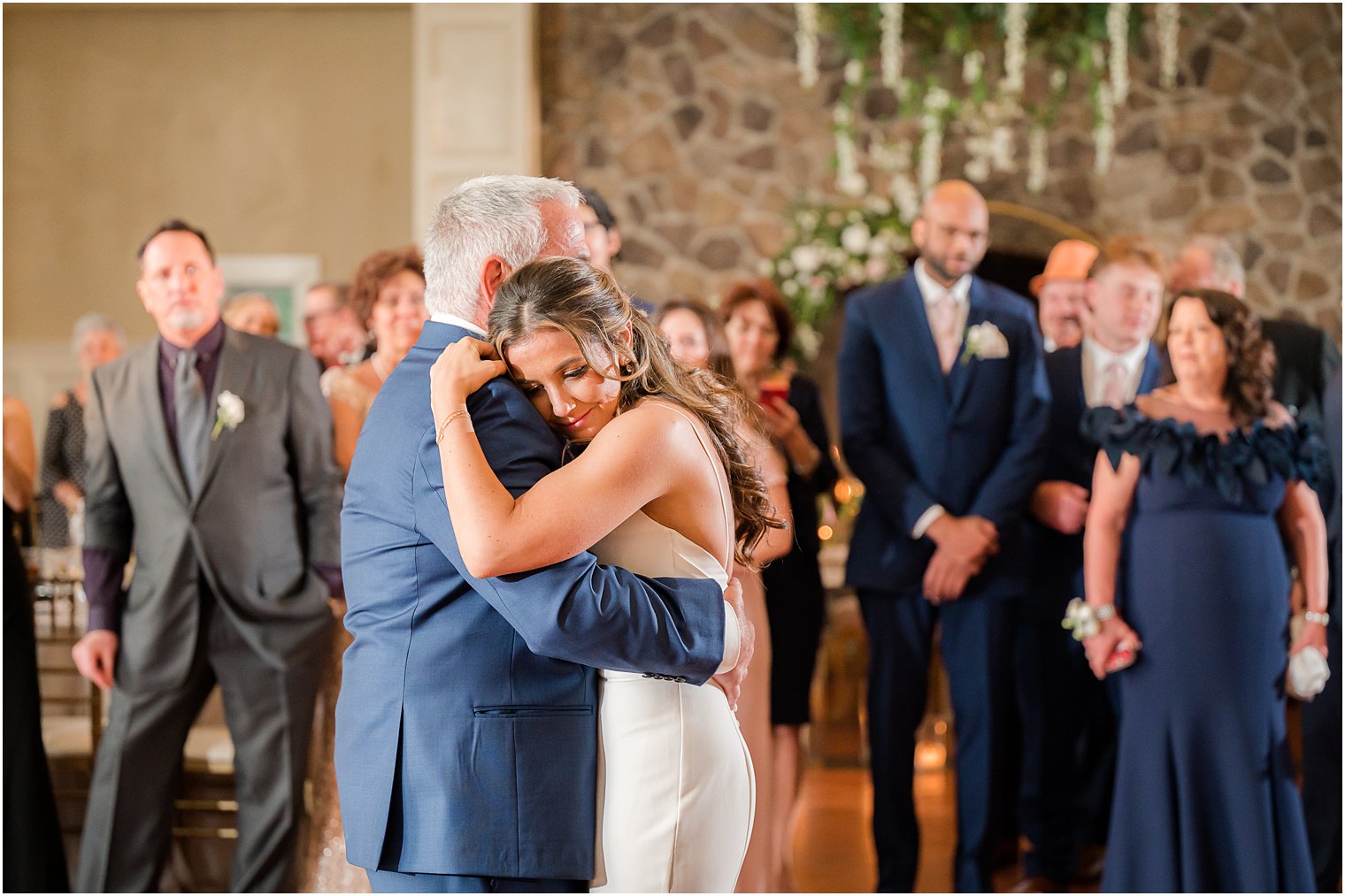 bride hugs dad leaning on shoulder during Ryland Inn wedding reception