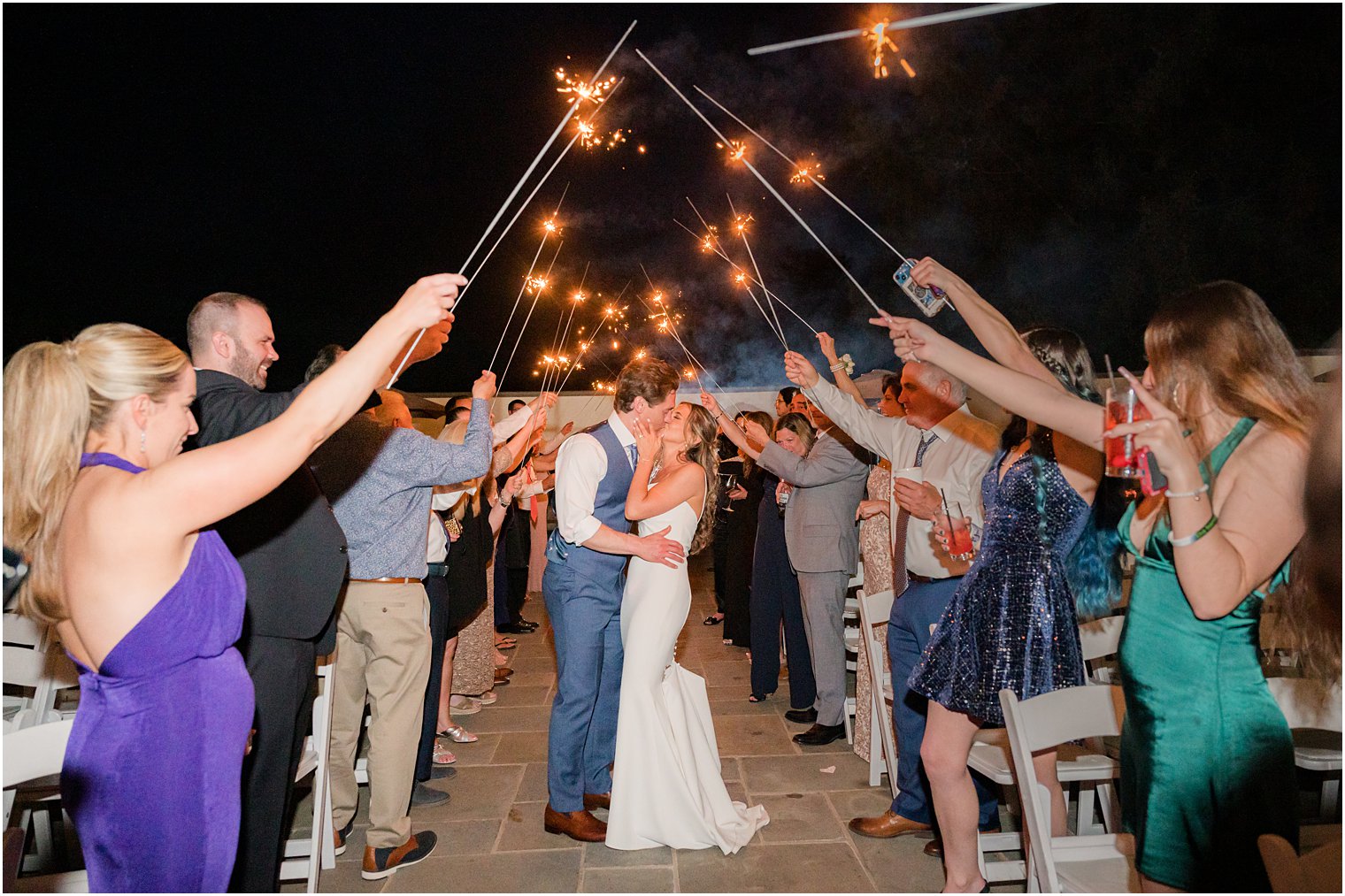 newlyweds kiss during sparkler exit from wedding reception