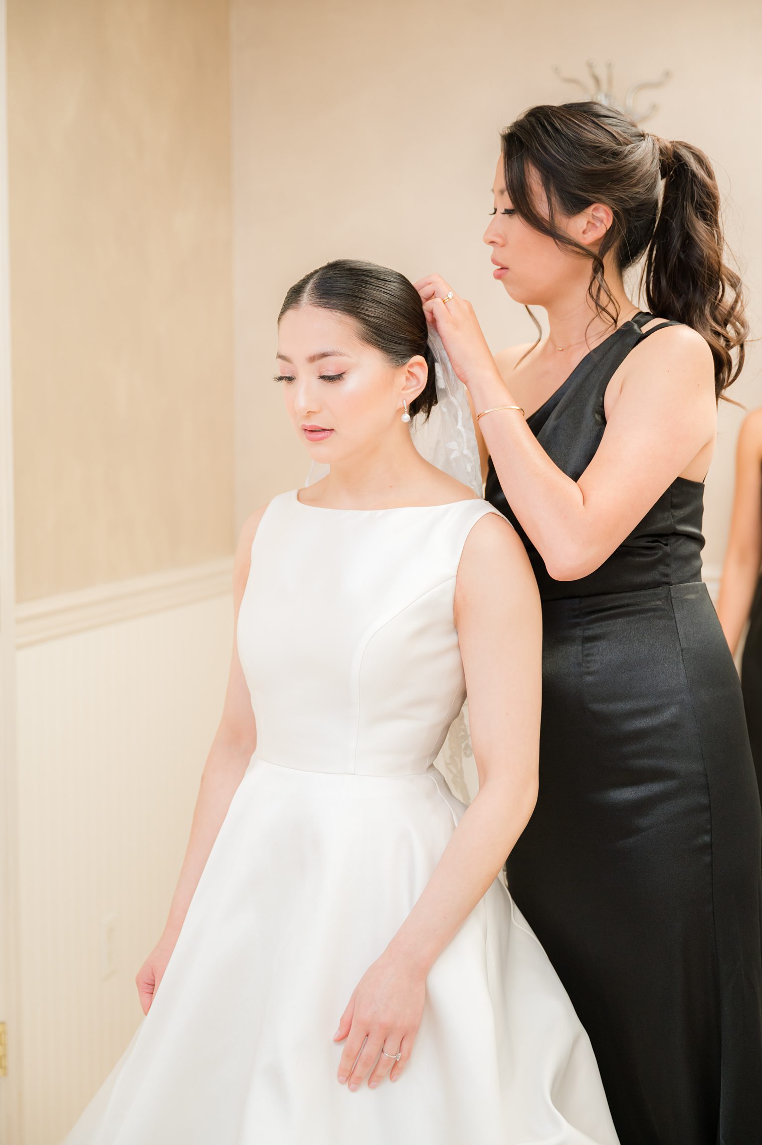 Bride and Bridesmaid helping with her hair 