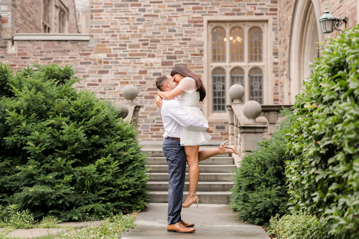 fiance holding up at his future bride at their engagement session at Princeton New Jersey 
