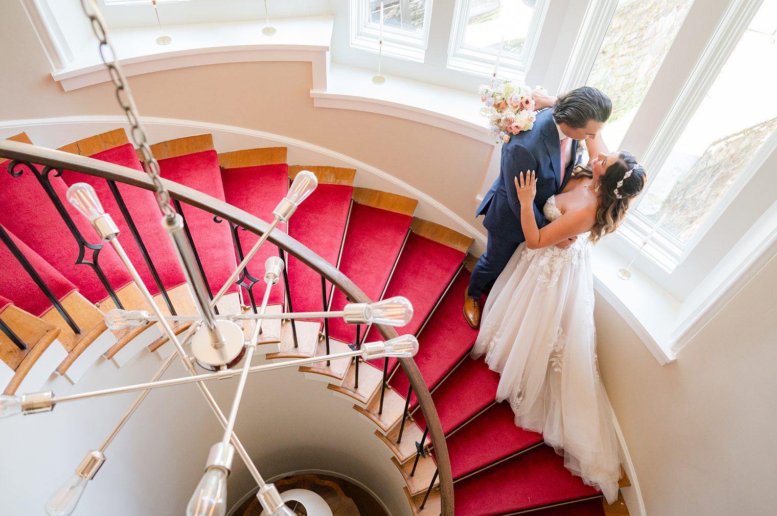 Bride and Groom looking each other in the stairs at Riverhouse at Rumson Country Club
