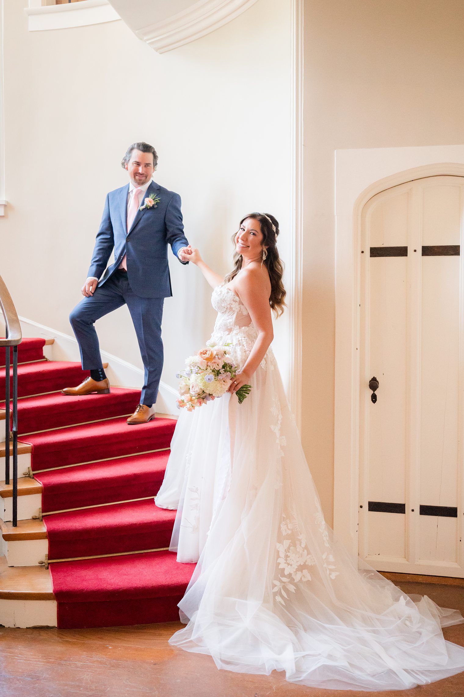 Couple posing for their wedding session in the stairs at Riverhouse at Rumson Country Club