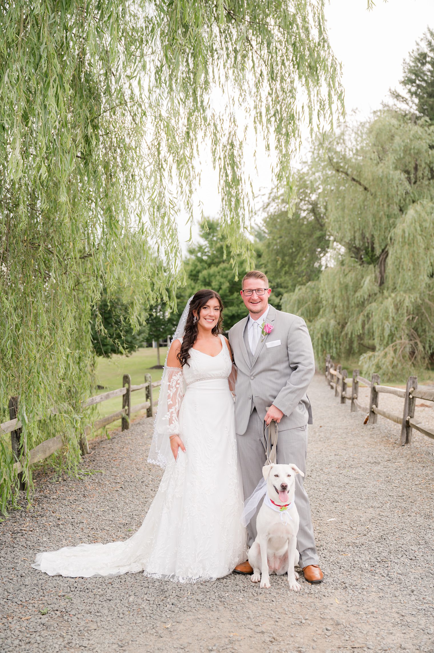 Couple with their pup in their wedding session at Windows on the Water at Frogbridge