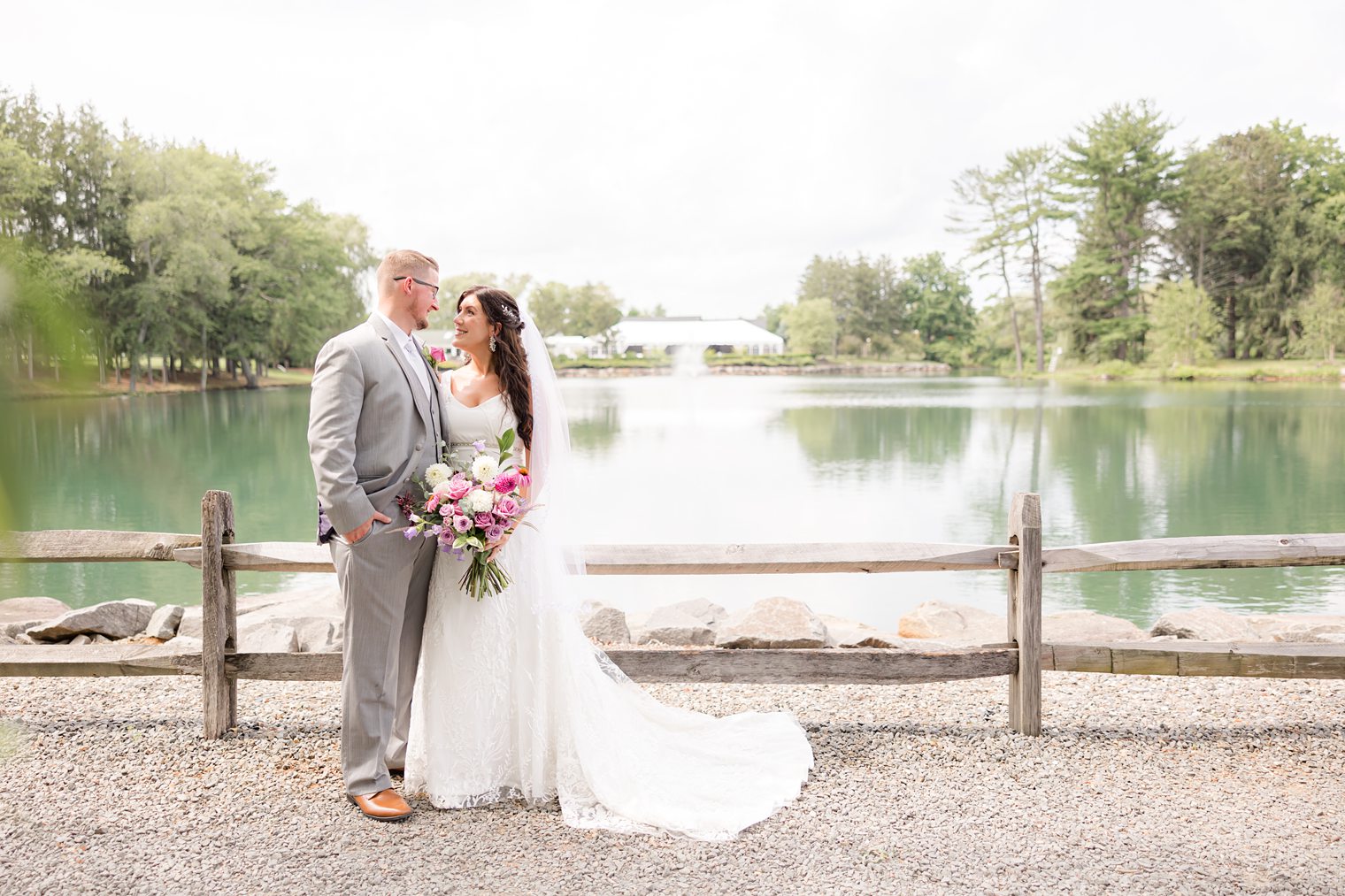 Beautiful couple posing in front of the venue they choose to say I do Windows on the Water at Frogbridge
