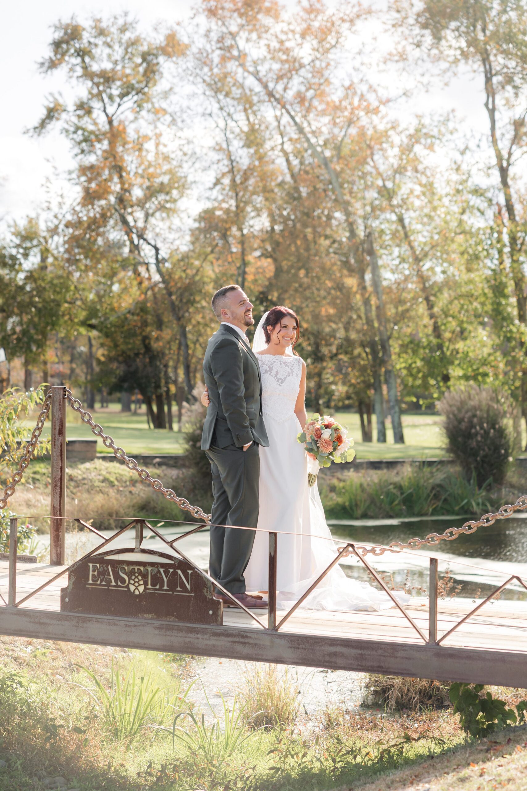 Bride and groom soak in the golden light of autumn, their hearts aligned as they pause in a peaceful, love-filled moment suspended in time