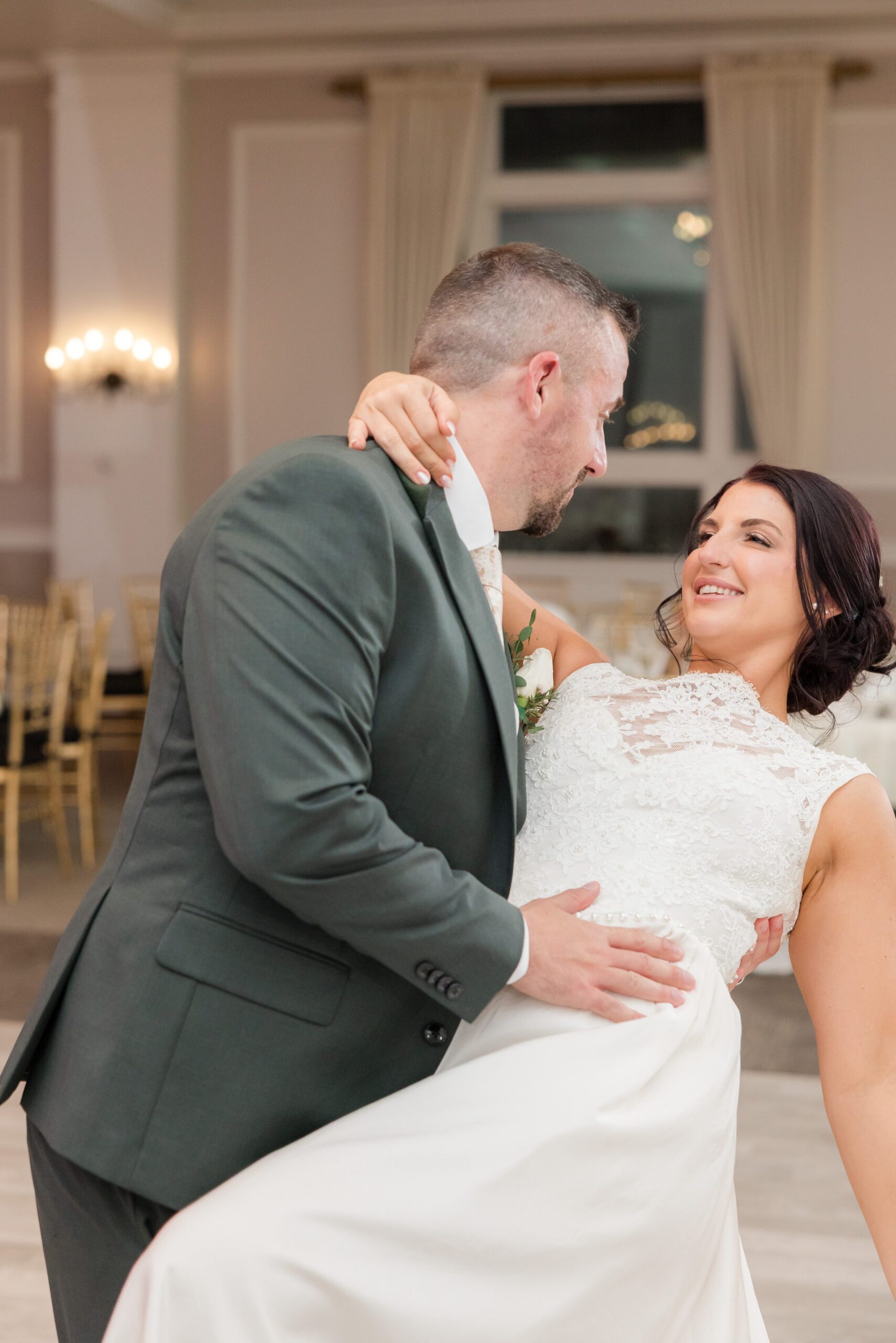 Groom dips the bride in a romantic embrace, their smiles full of love and trust