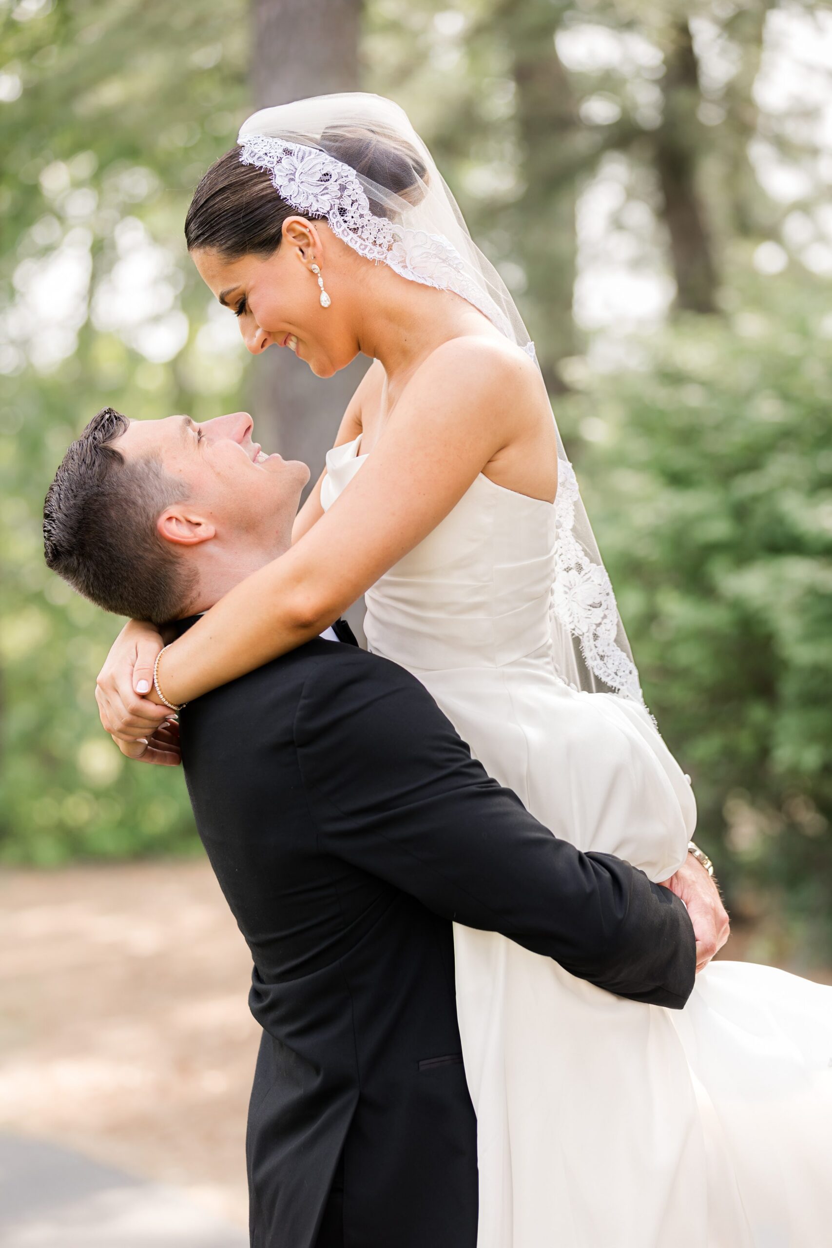 Groom lifting the bride as they smile at each other, lost in a romantic embrace
