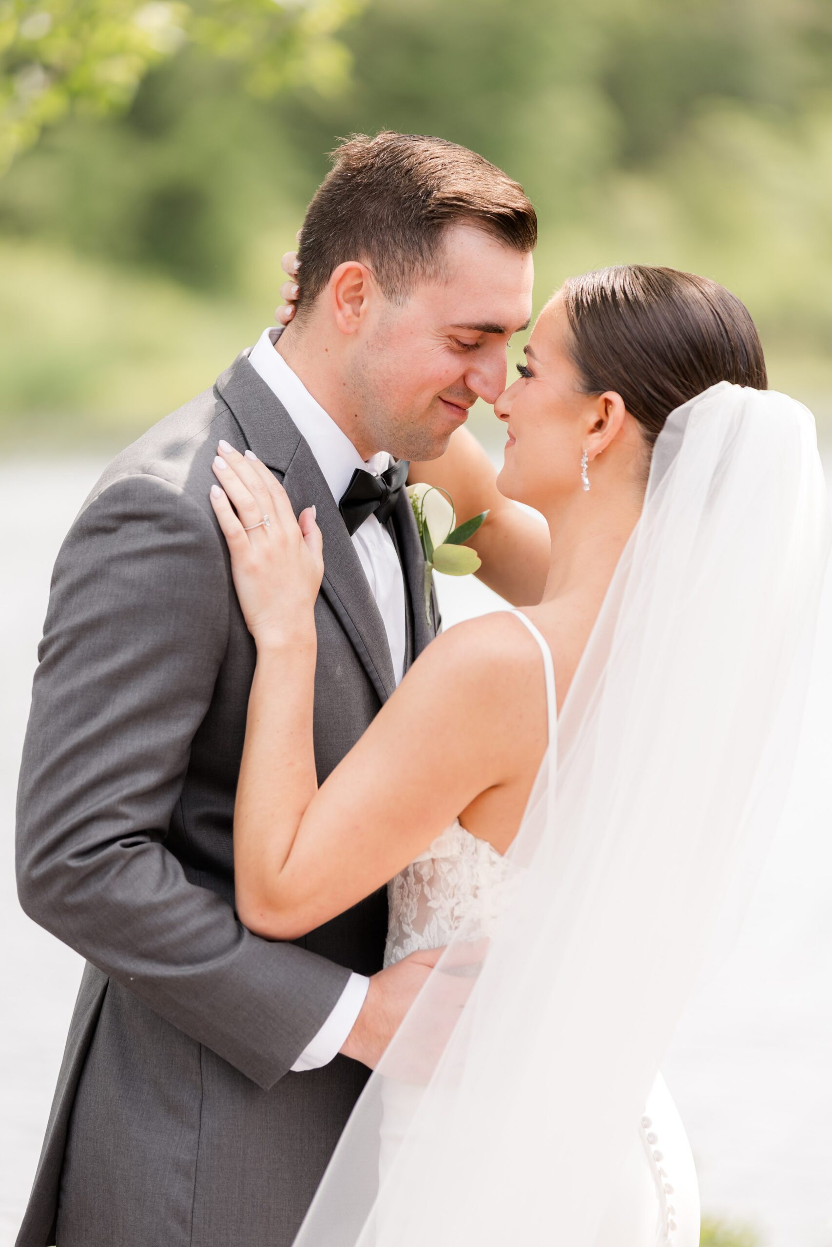 Half-body shot of bride and groom holding each other, and nose-to-nose