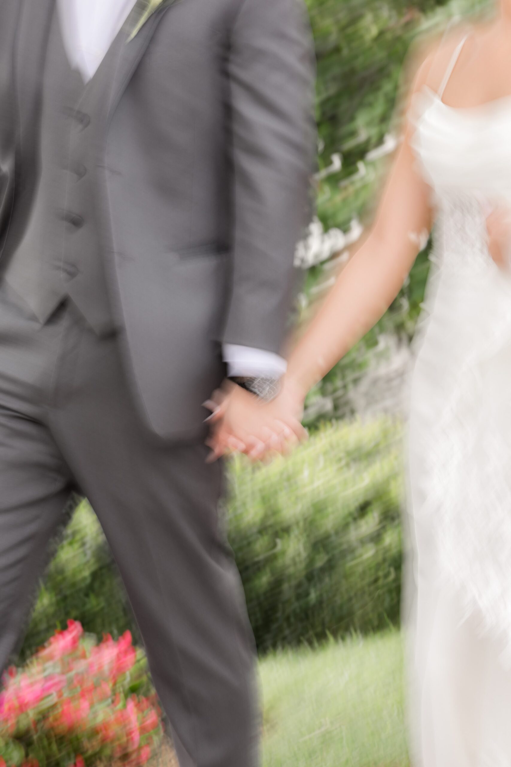 Blurred closeup shot of bride and groom holding hands