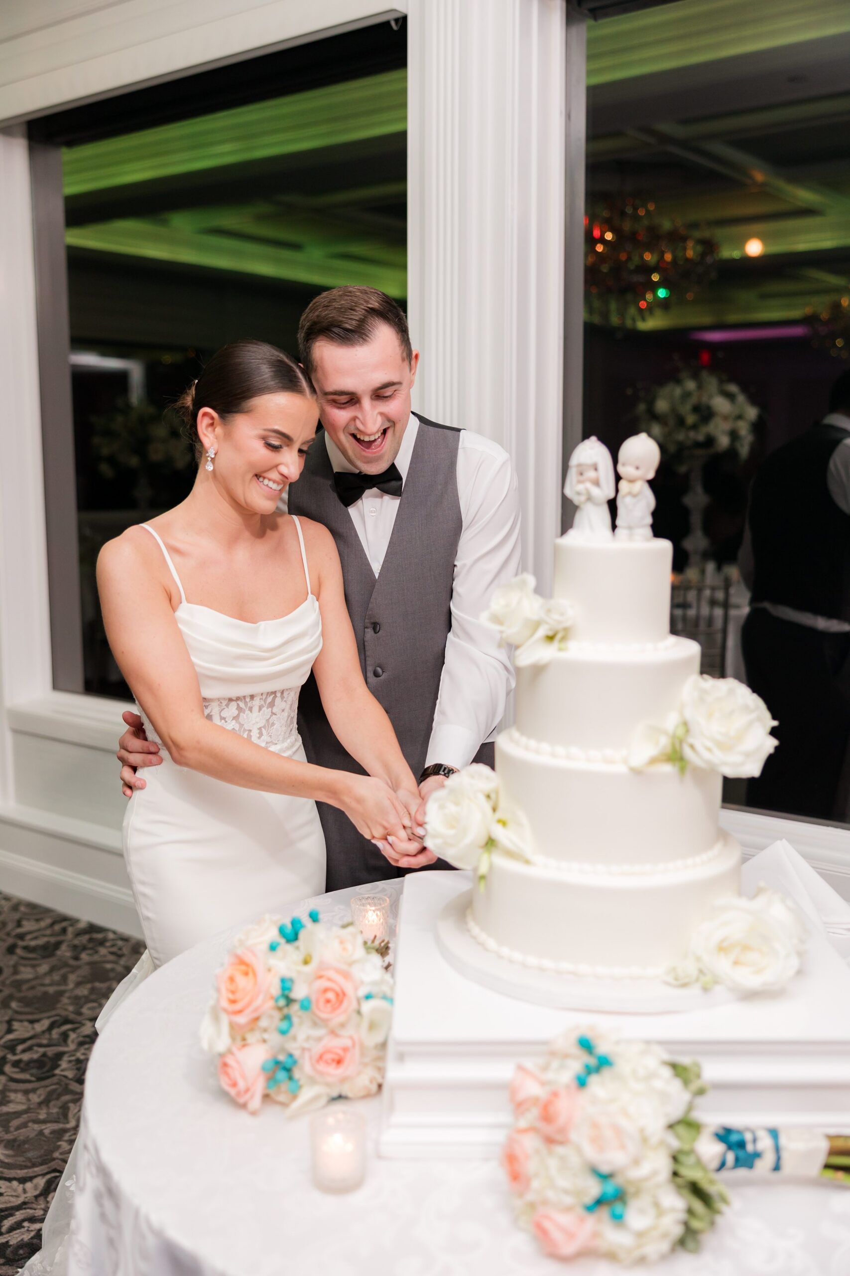 Bride and groom cutting into a 3-tier cake, holding the knife together