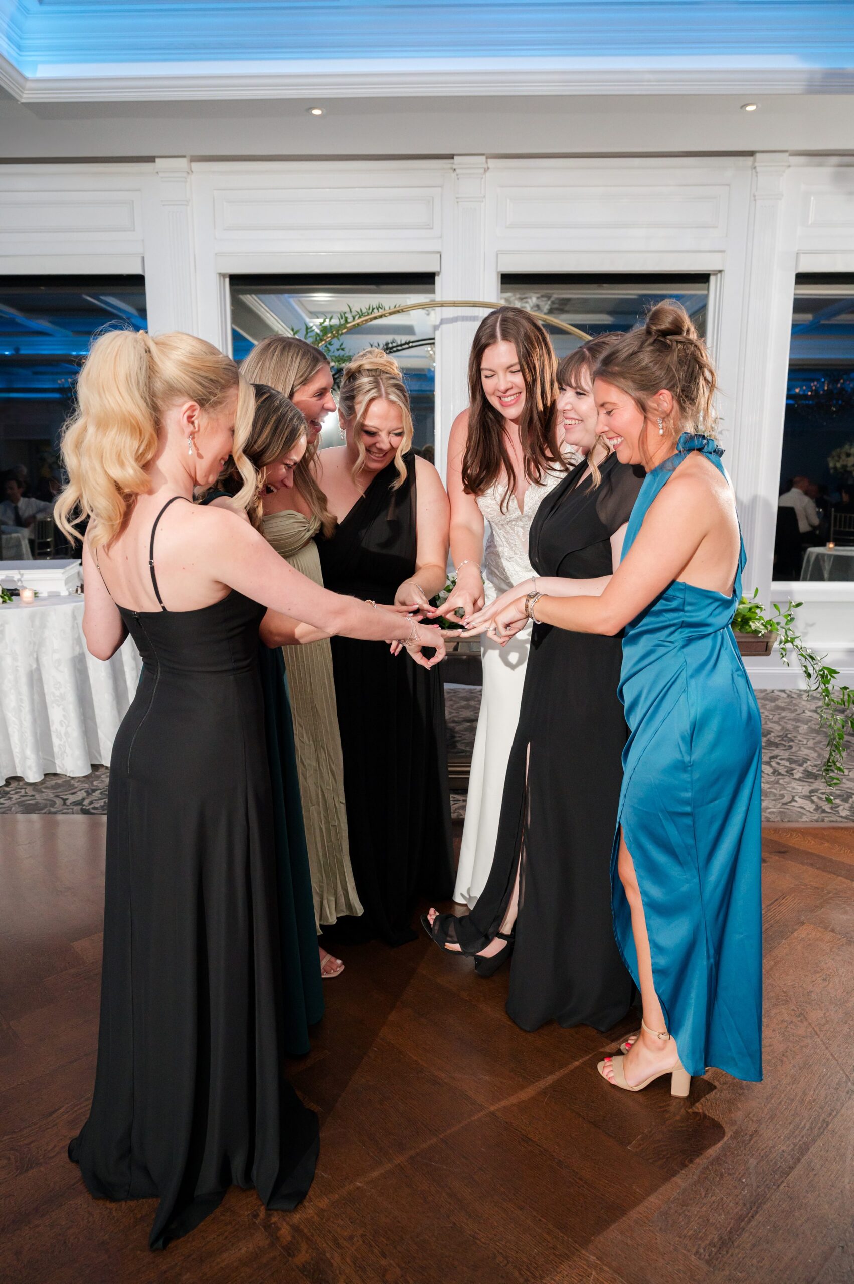 Bride celebrating with her friends on the dance floor, gathered in a joyful circle as they toast together during the reception