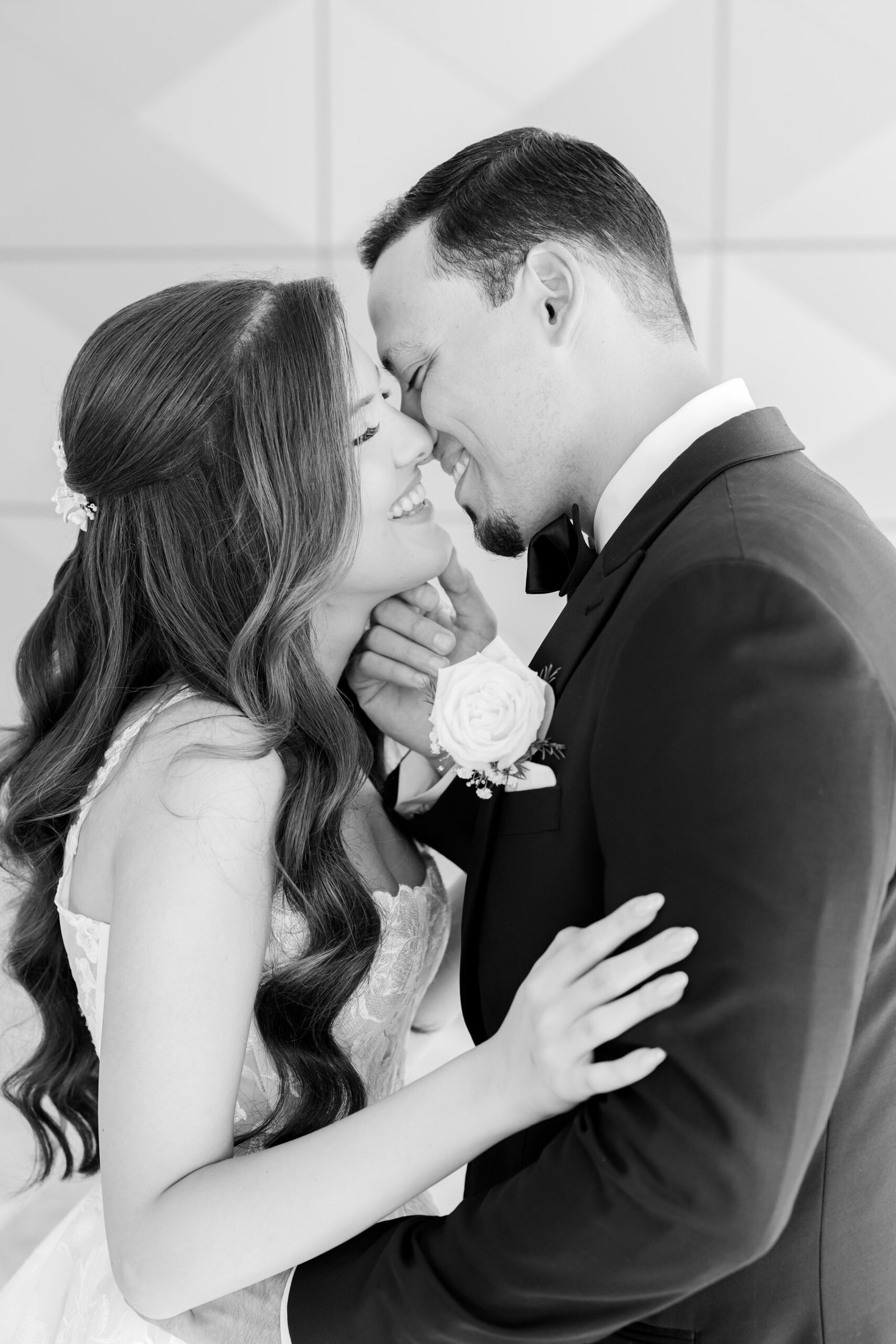 Black and white close-up of the bride and groom holding each other in a tender moment