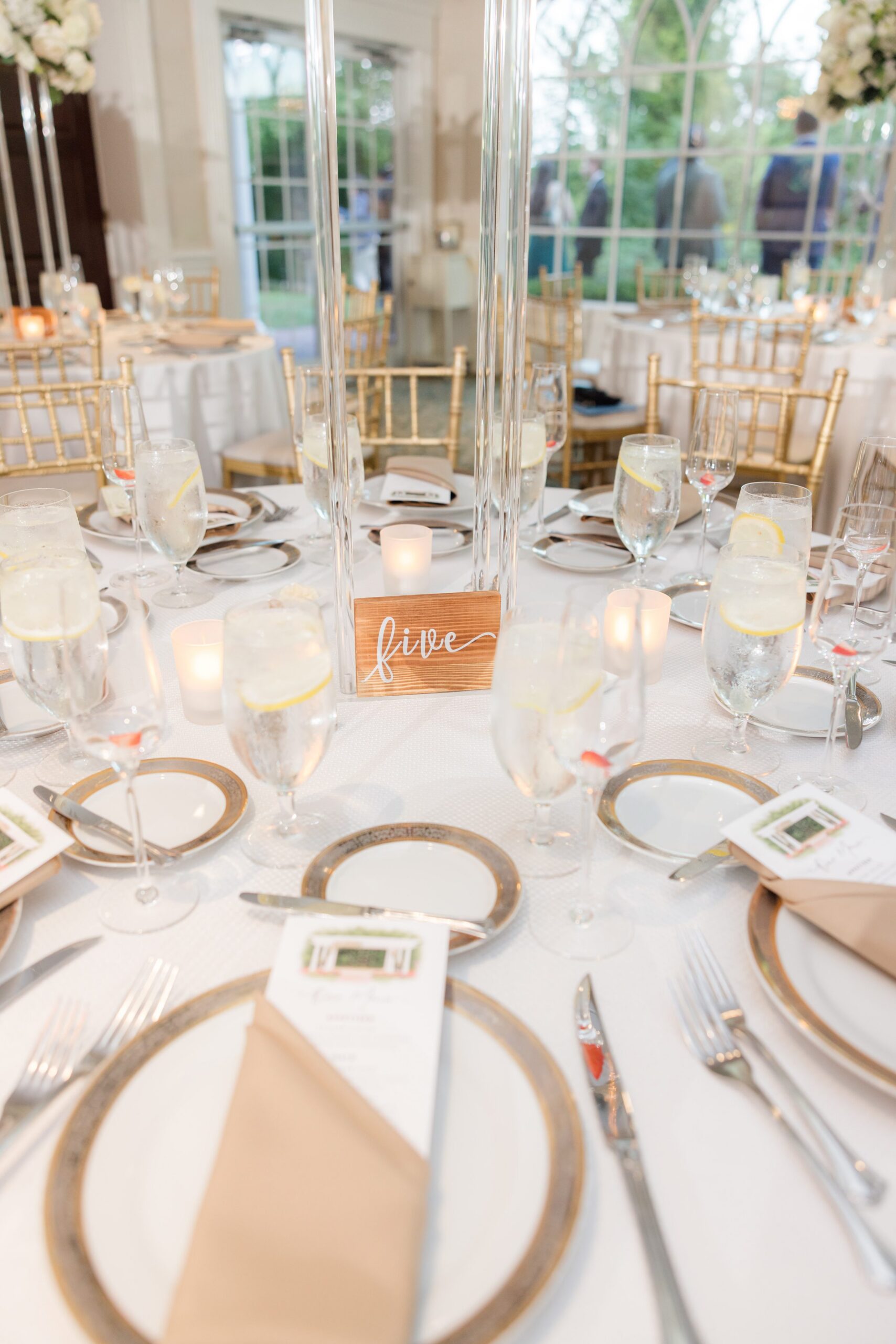 Elegant reception table setting with gold accents and soft neutral tones, ready for guests to gather