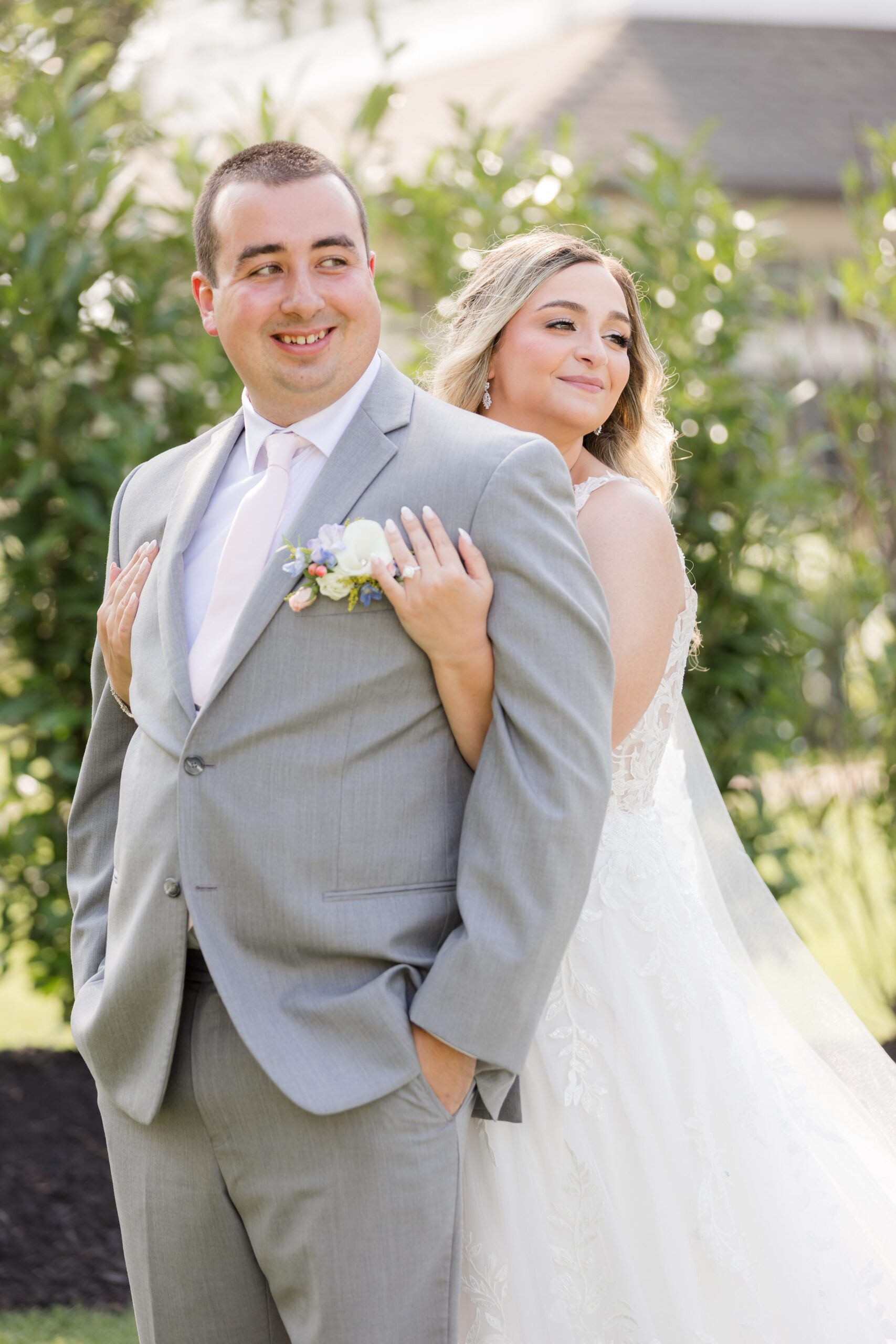 Katherine and Henry smiling with the bride embracing the groom from behind