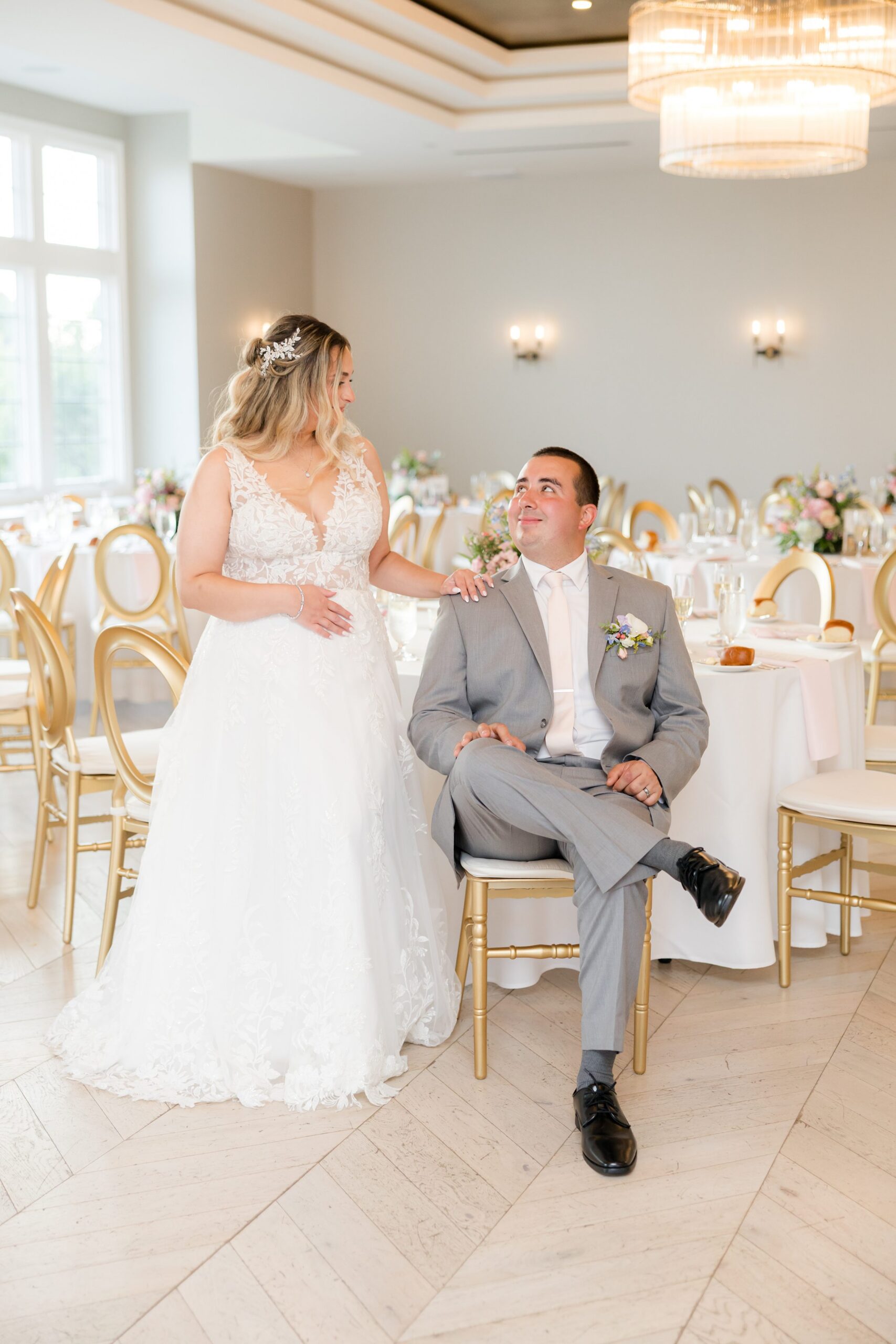 Bride standing beside the seated groom in the reception room