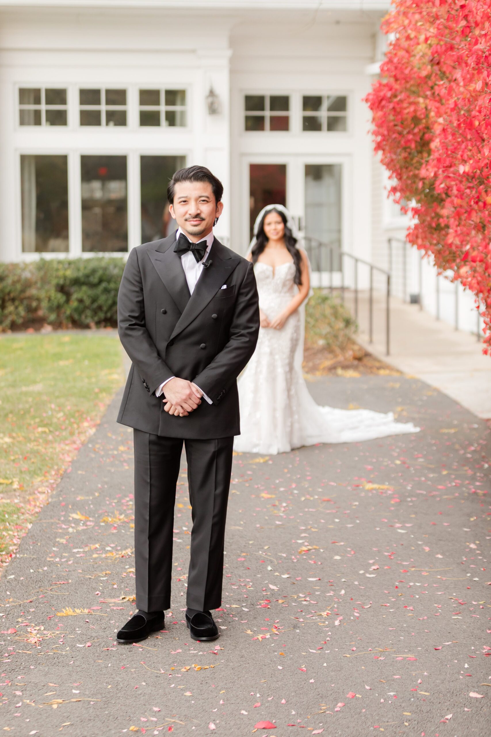 Groom waits with a gentle smile as his bride approaches from behind, creating a moment full of anticipation