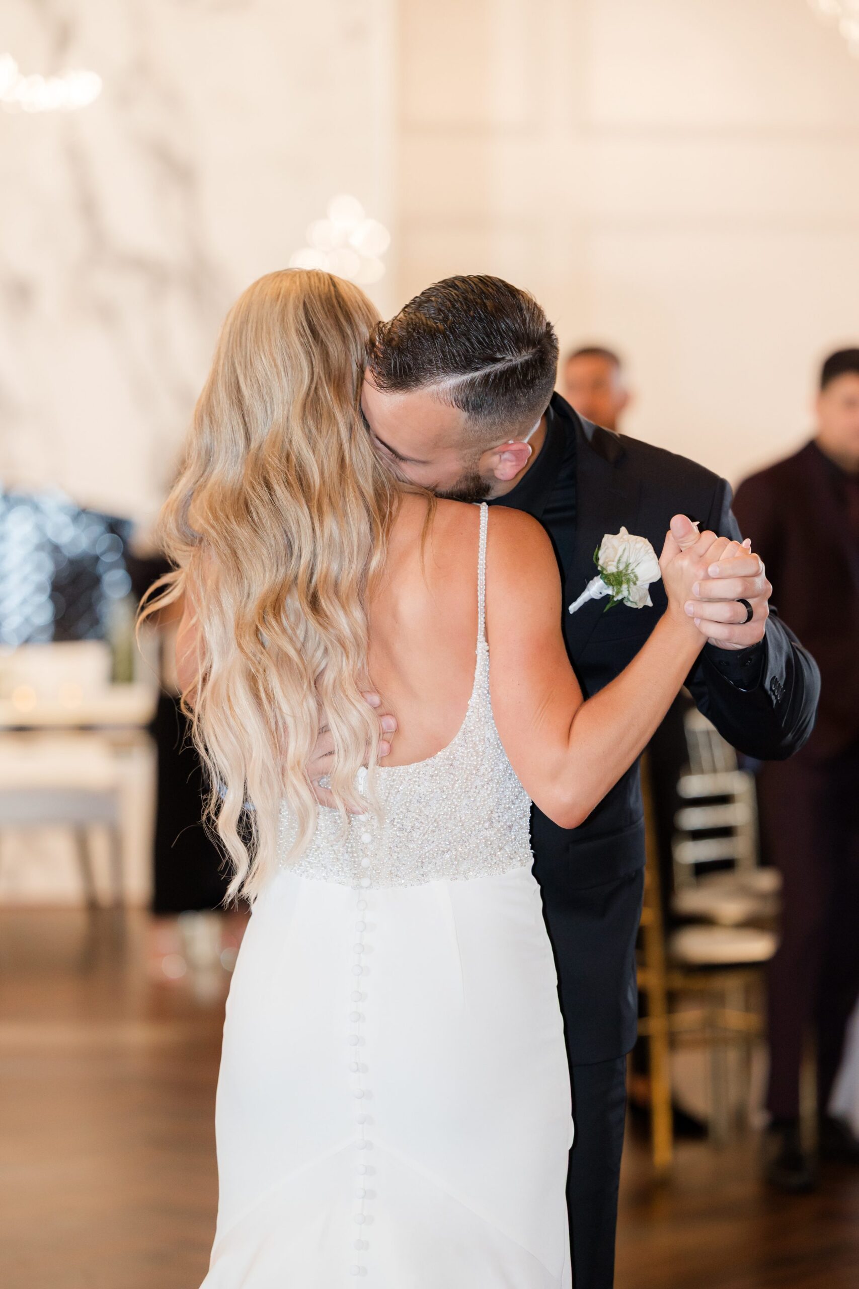 Bride and groom sharing a slow, intimate dance, holding each other closely on the reception floor