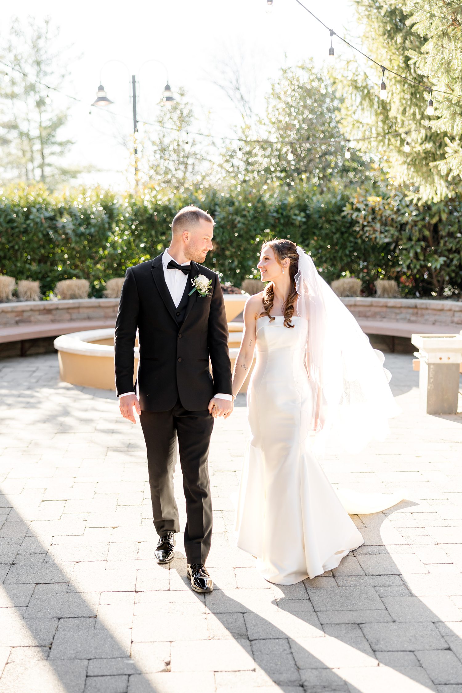 Bride and groom walking outdoors in golden sunlight