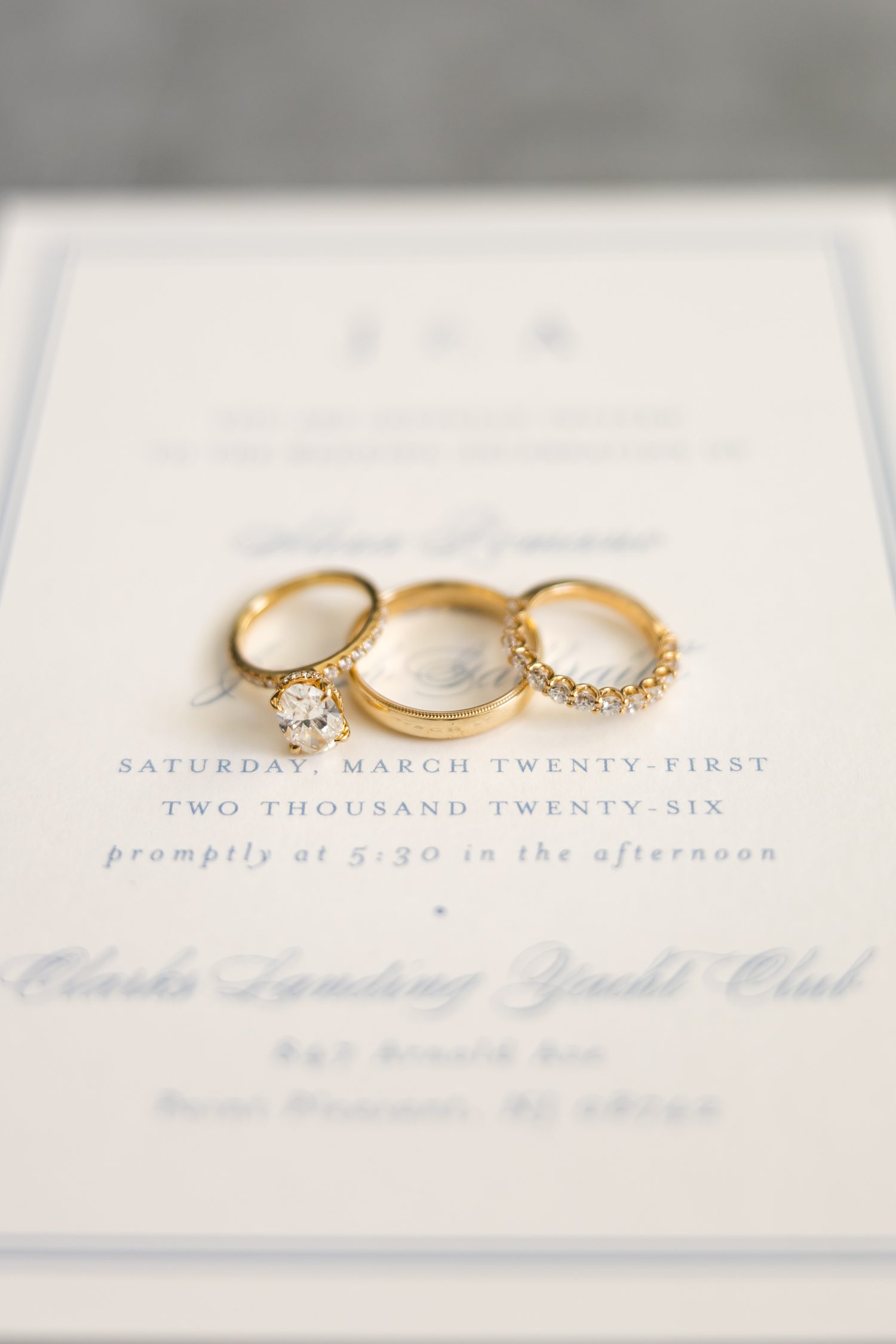 Gold wedding rings displayed on elegant invitation suite with luxury details