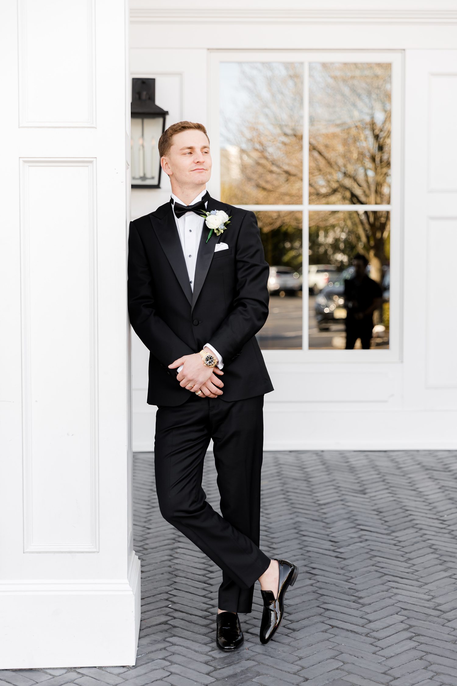 Groom posing confidently outside luxury yacht club wedding venue