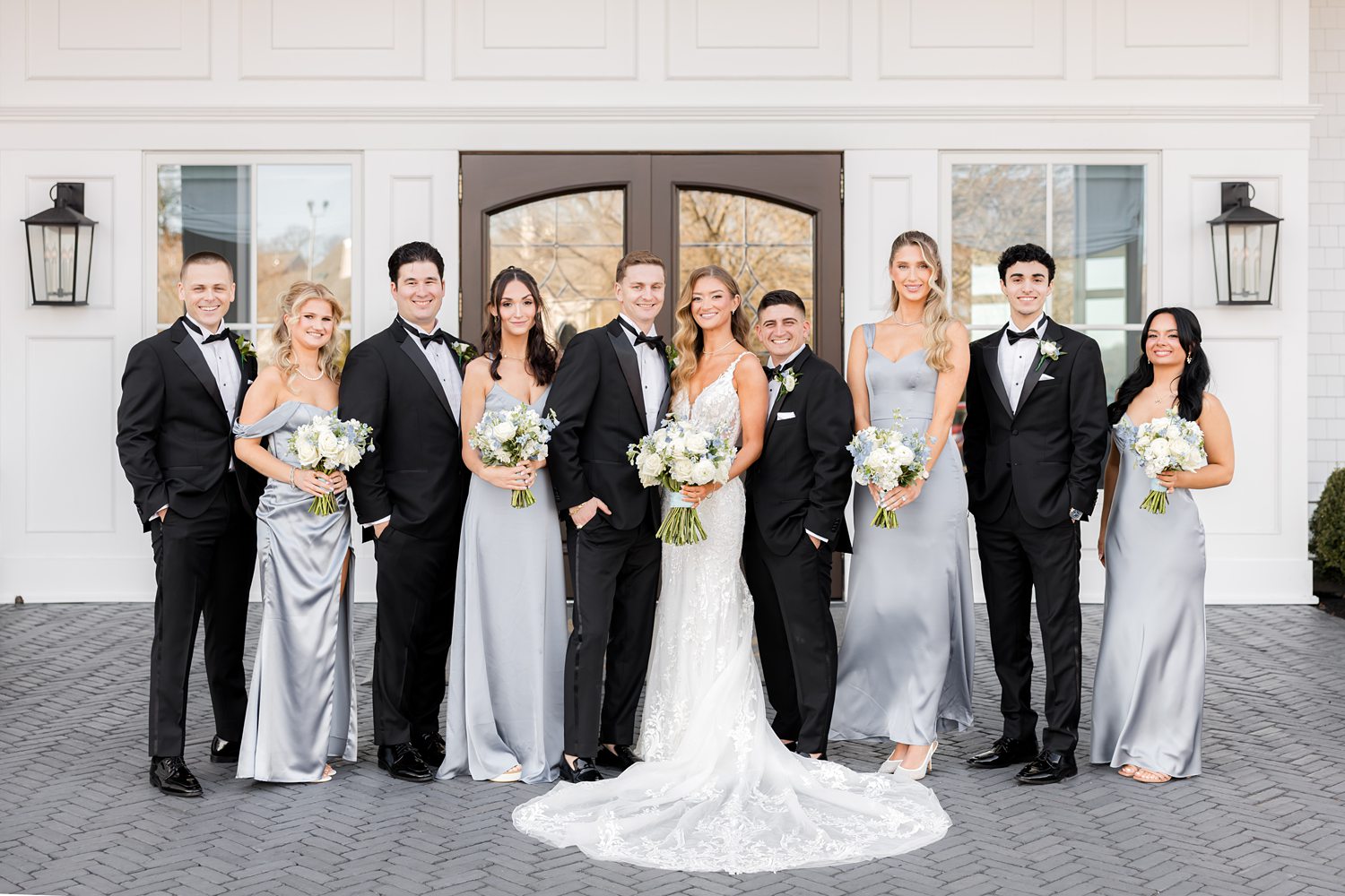 Wedding party celebrating together outside elegant waterfront venue