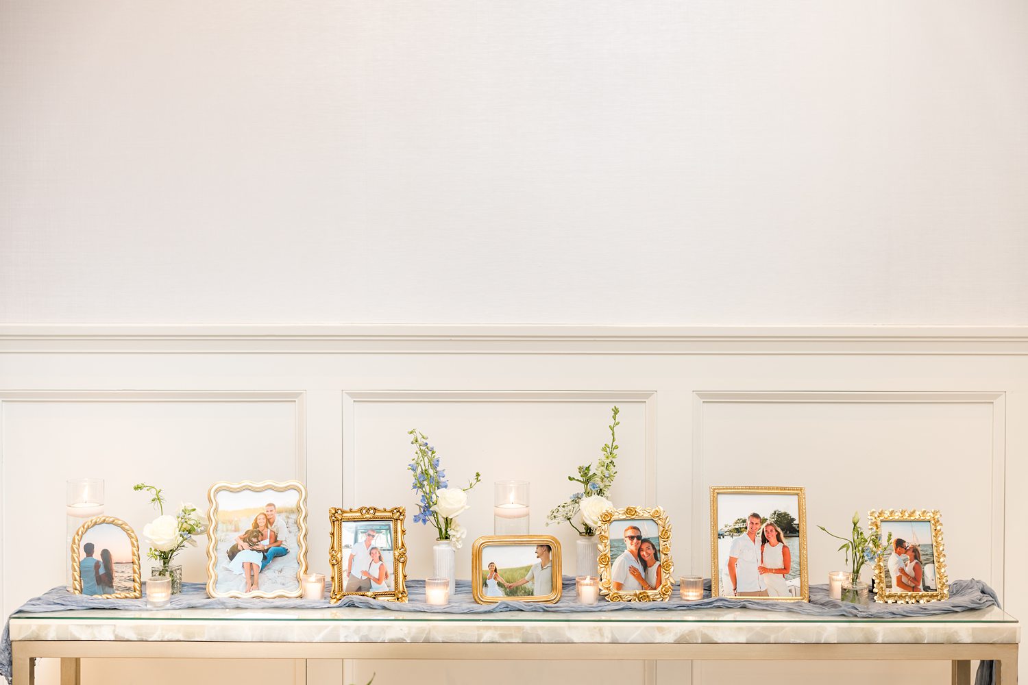 Wedding escort card display table with elegant gold accents and candles