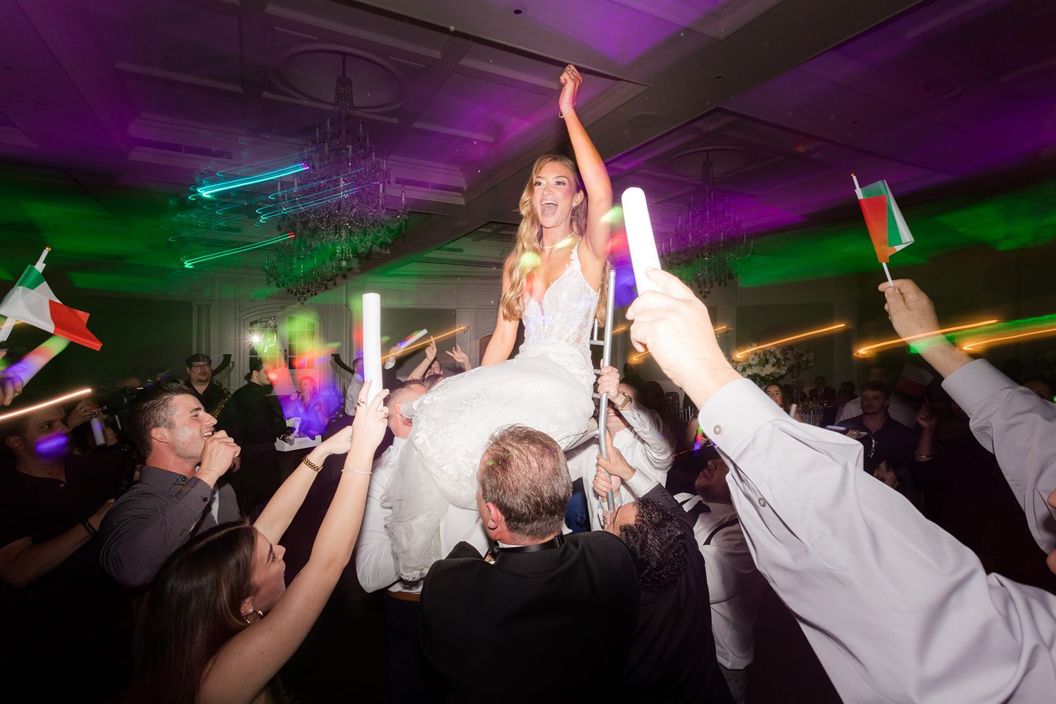 Bride crowd surfing during energetic wedding reception dance party